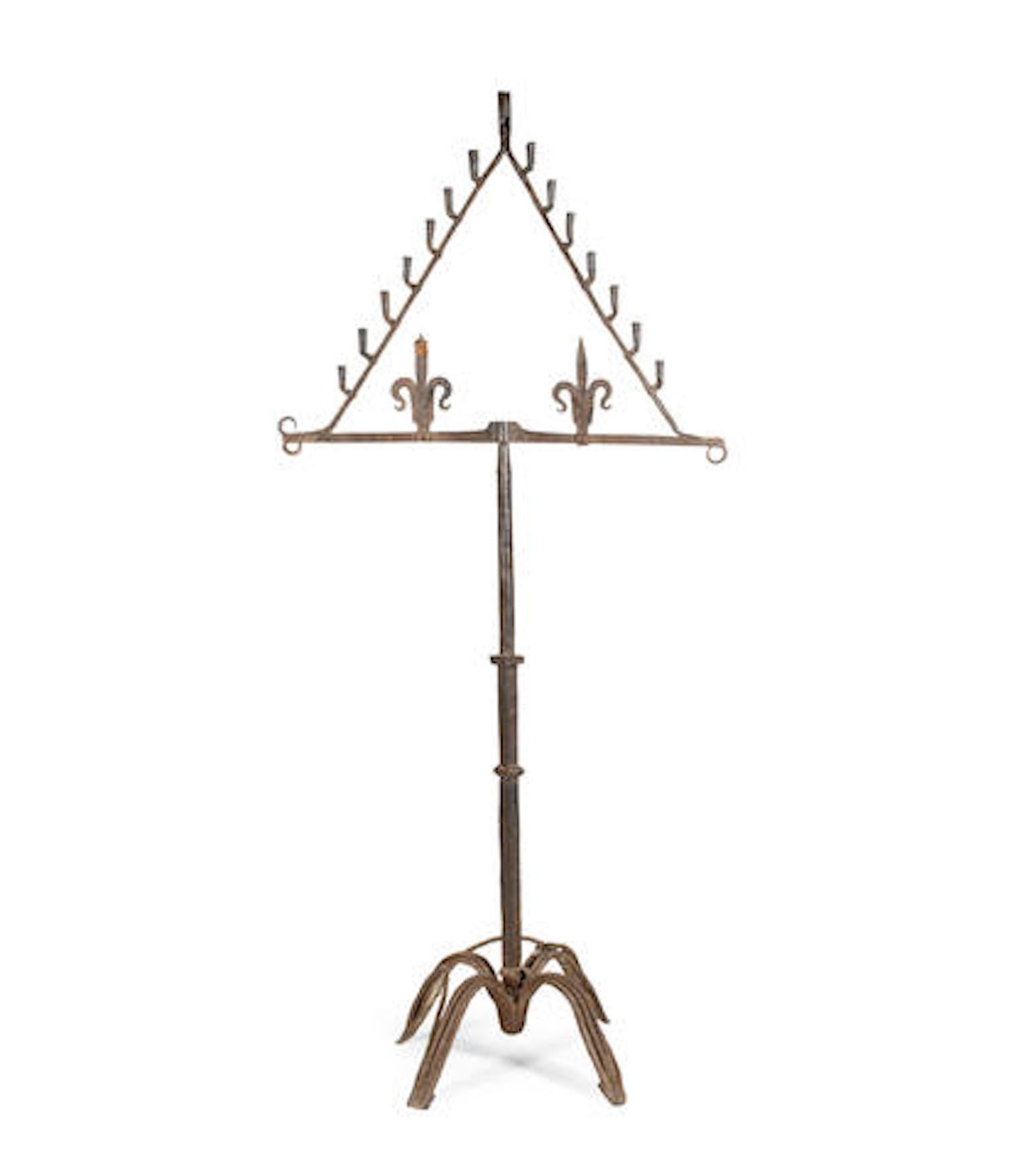 - Striking Spanish wrought iron standing torchère in the Renaissance style

With fifteen rolled candle-sockets, and two decorative fleur-de-lys finials, on a knopped square-section stem and four downswept legs decorated with spiral-twist iron