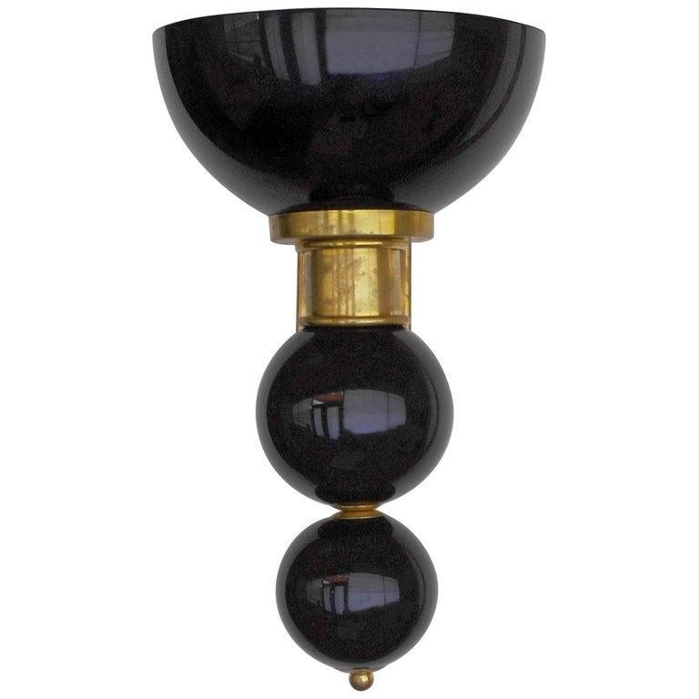 Italian wall light shown in hand blown black Murano glass, mounted on un-lacquered brass frame / Designed by Fabio Bergomi for Fabio Ltd / Made in Italy.
1 light / E26 or E27 type / max 40W
Measures: Height 16 inches, width 10 inches, depth 11