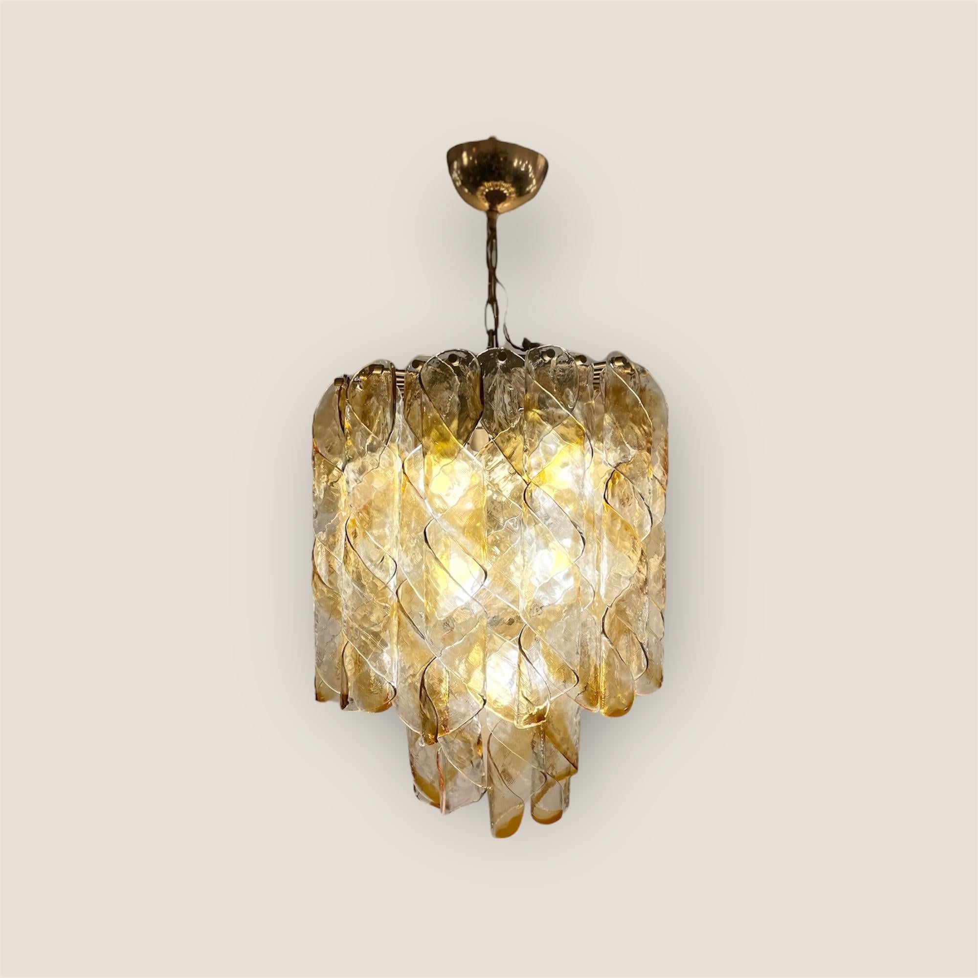 Eleganza di una grande lampada a sospensione, un lampadario, composto da 32 foglie attorcigliate in vetro di Murano soffiato a mano con effetto ambrato e trasparente, sospese a una struttura in ottone. Chiamato Torciglioni, questo pezzo senza tempo