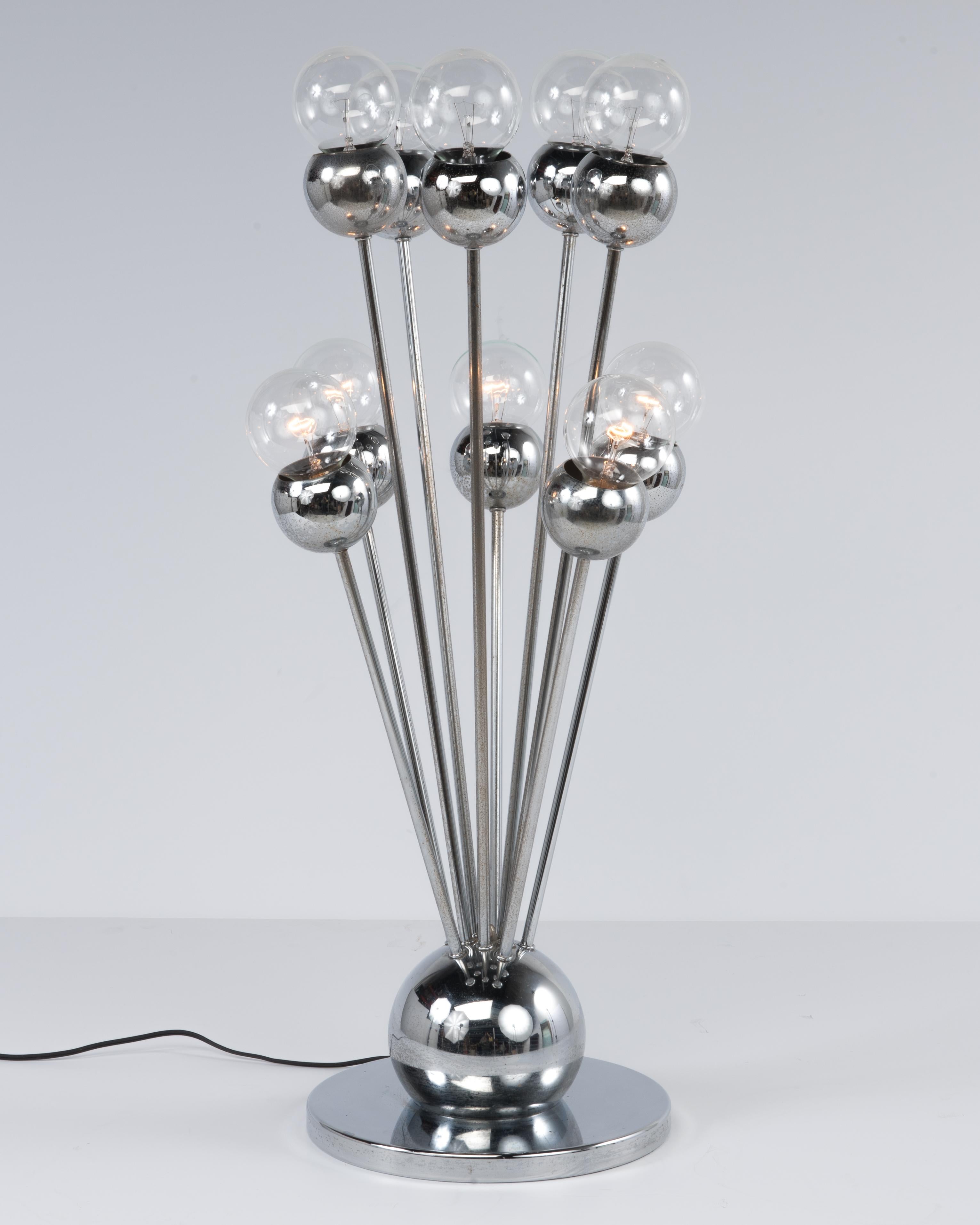 A large and impressive chrome table lamp attributed to Torino of Italy. The dimensions given are as shown in the first photograph. Without the bulbs the height is 28 1/2 inches. The base is 11.25 inches around. The new light bulbs used only for the