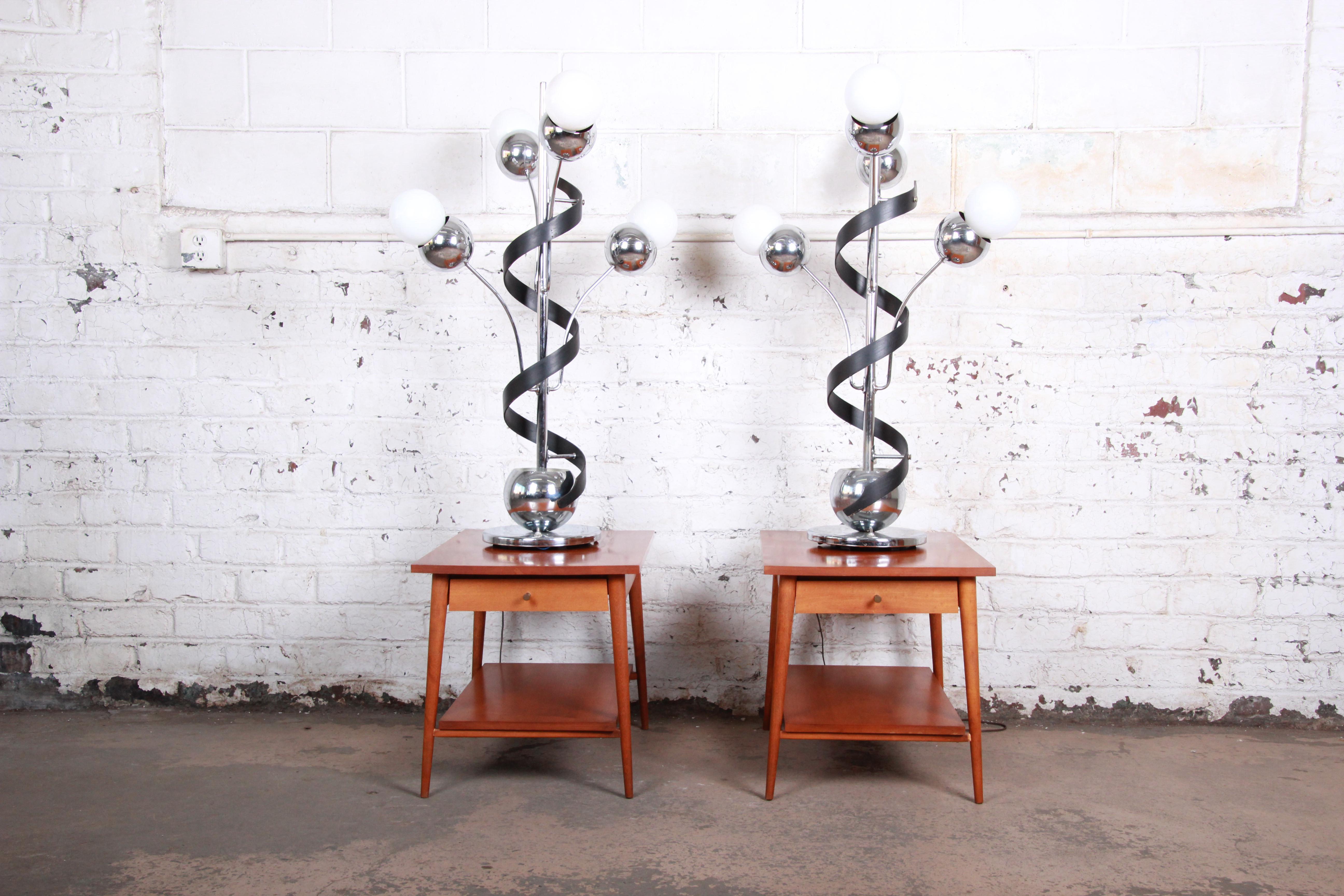 An exceptional pair of oversized Torino style Mid-Century Modern Space Age Sputnik table lamps. The lamps feature heavy chrome frames, each with four arms and a unique ebonized bentwood corkscrew design. They offer three-way lighting, and each lamp
