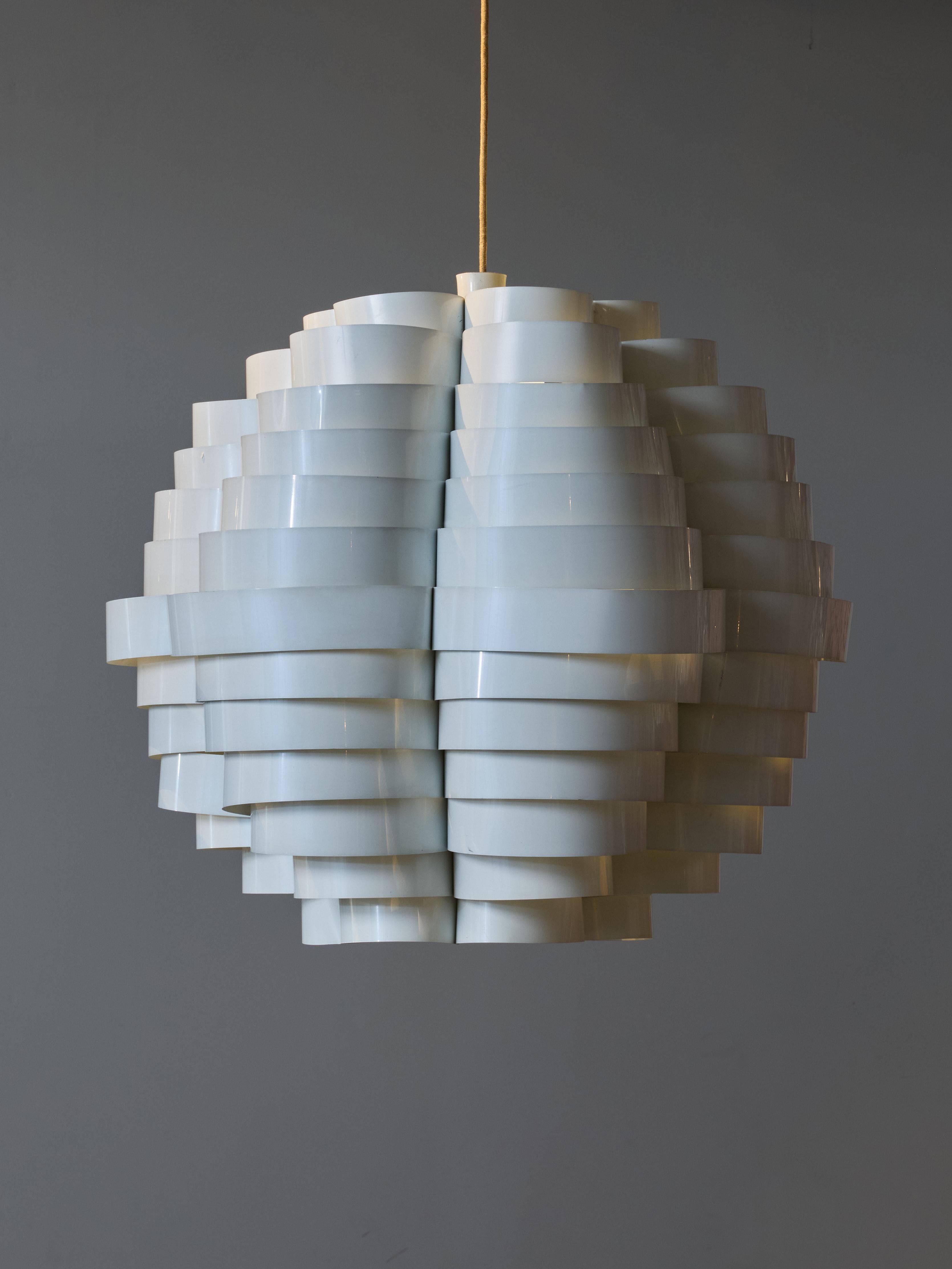 Decorative piece designed by Elio Martinelli for his own firm “Martinelli Luce” under the name Tornado, or reference 1770.
This chandelier is made of thin aluminum sheets bent with several radiuses to create the overall shape. One source of light in