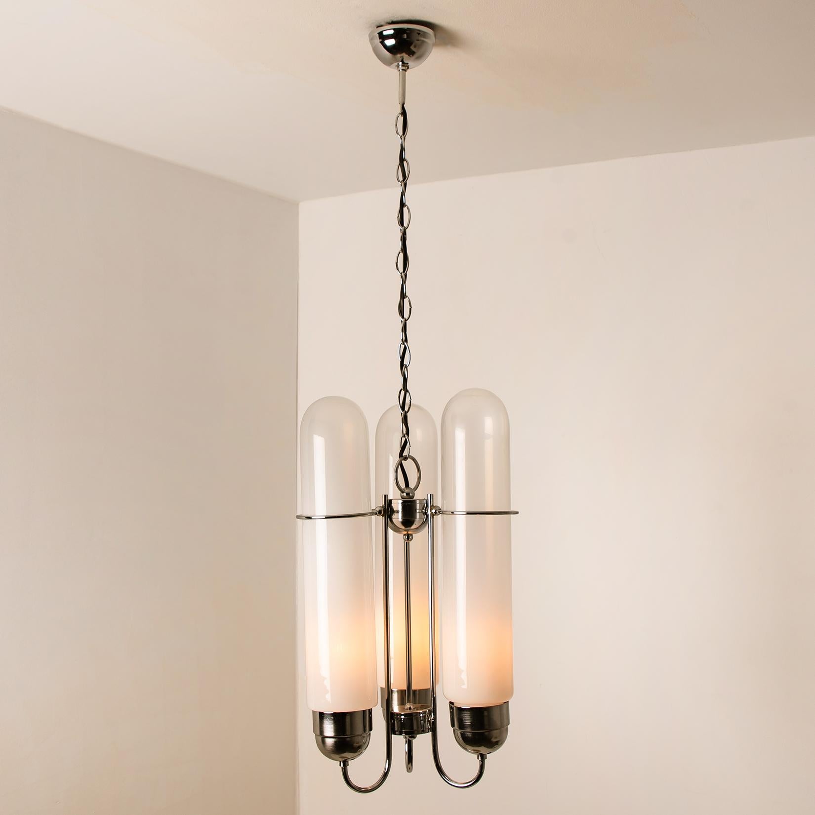Torpedo chandelier by ldo Nason for AV Mazzega. Manufactured in midcentury, circa 1970 (at the end of 1960s and beginning of 1970s). Handmade and high quality piece. 3 hand blown Murano opaque/milky crystal glass “torpedoes”. Chromed metal parts