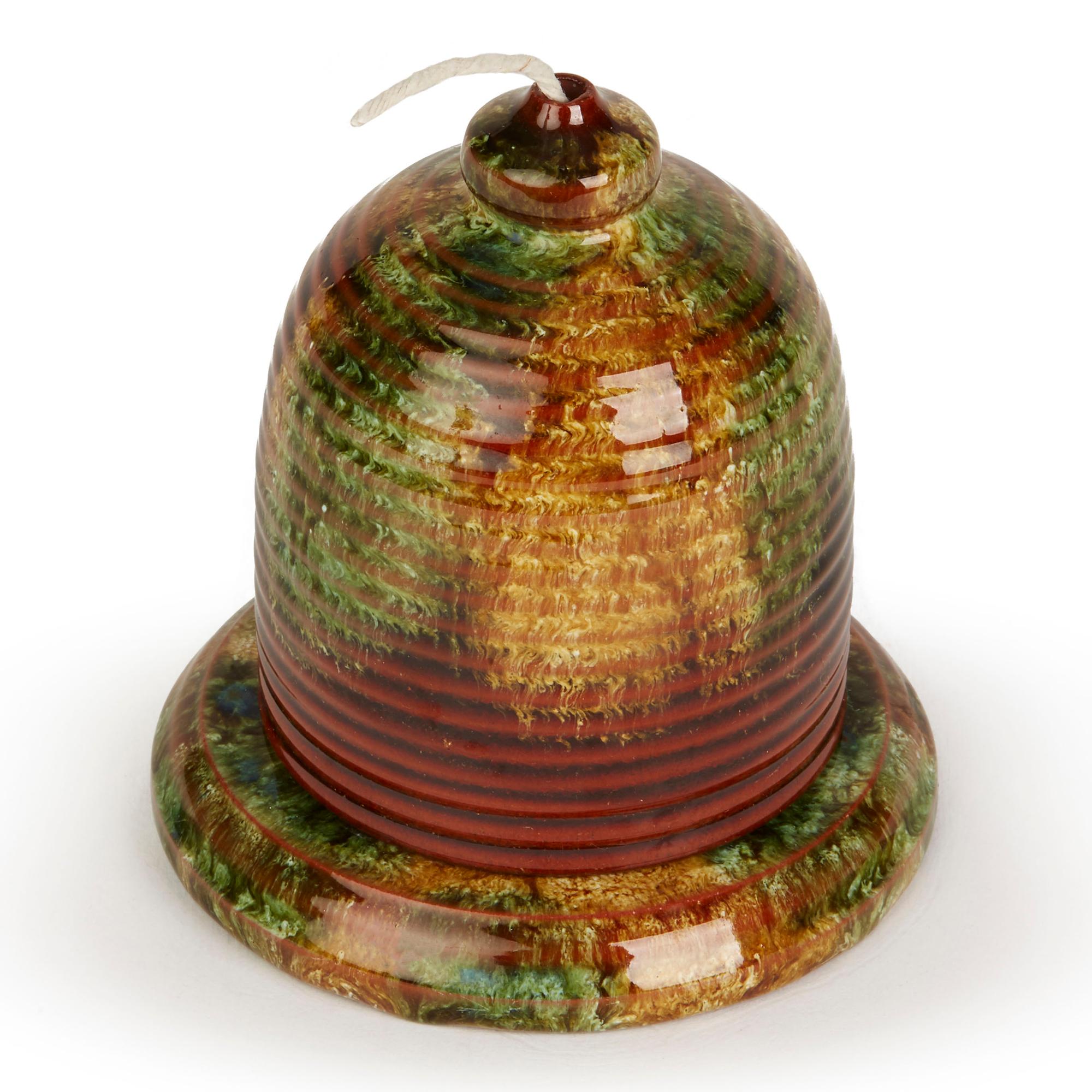 A rare Art Nouveau Torquay Terracotta Co, Stapleton glazed pottery string dispenser of beehive shape on a rounded pedestal base with a raised string compartment to the inside dating from around 1900. The dispenser is decorated in streaked, green,