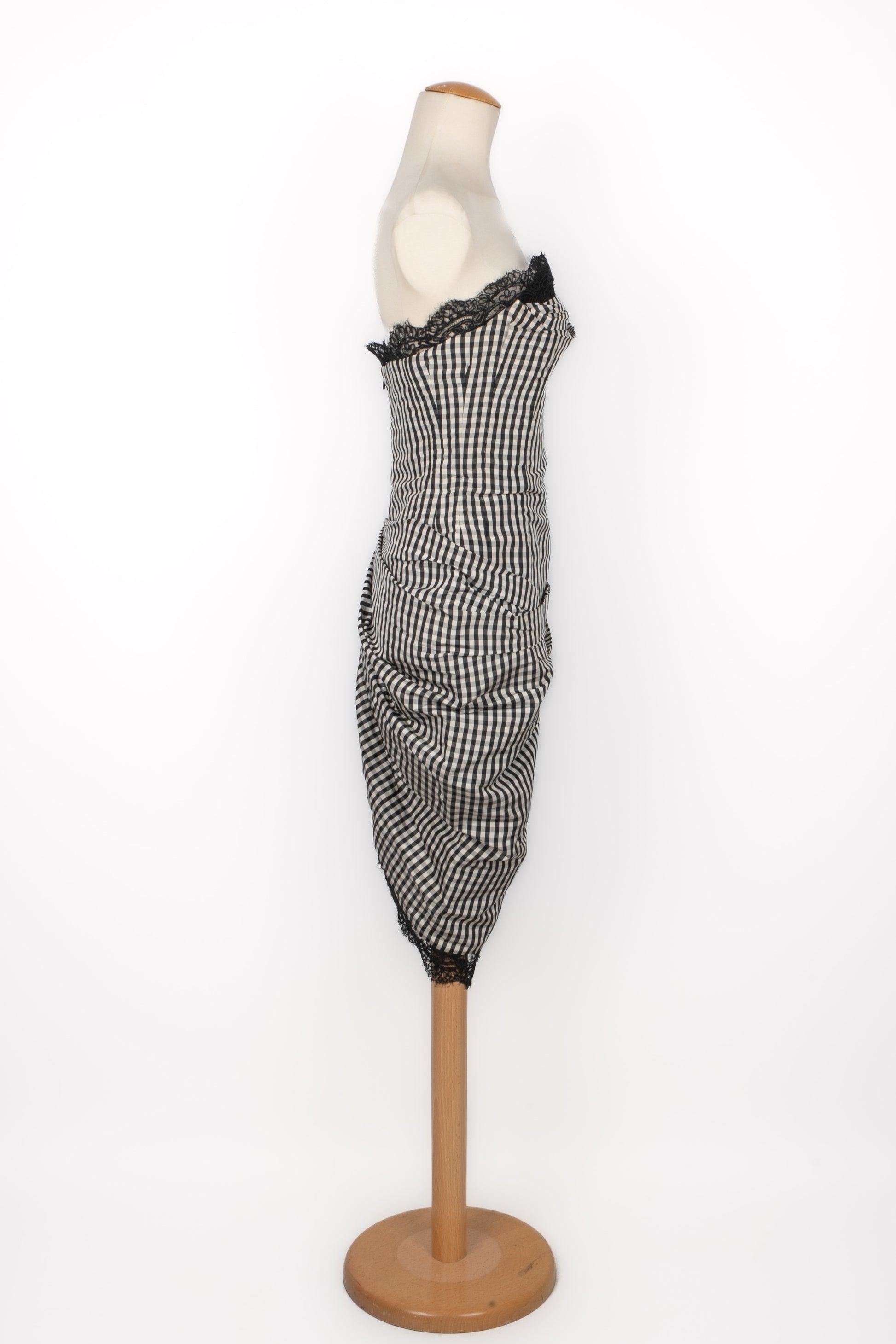 Torrente - Vestido bustier de cuadros blancos y negros ribeteado con encaje negro. No se indica la talla, se ajusta a una 36FR/38FR. Una Colección de Alta Costura 1996.

Más información:
Estado: Muy buen estado
Dimensiones: Pecho: 40 cm - Cintura: