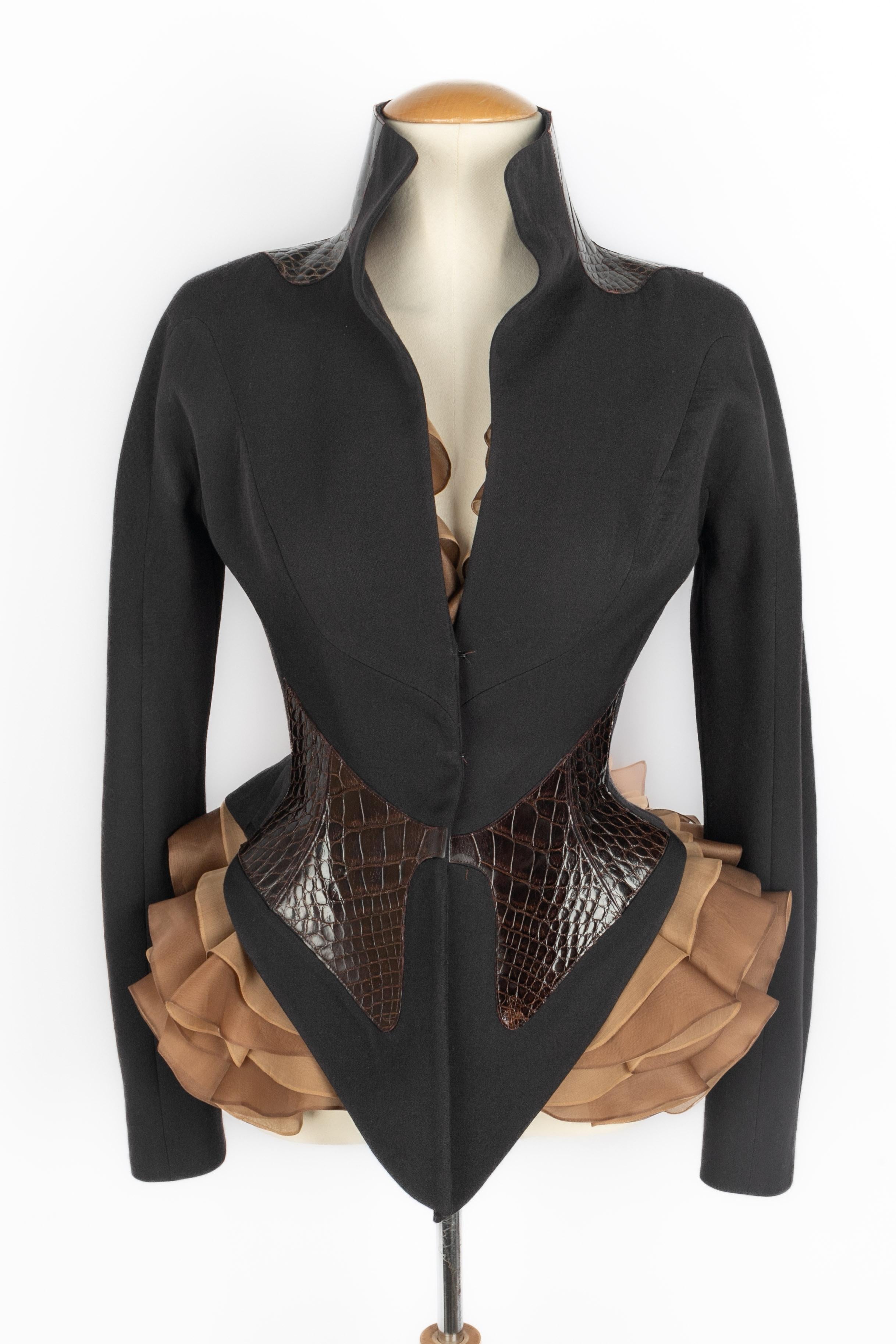 TORRENTE - Set composto da una giacca aderente marrone con intarsi in pelle esotica in vita e sul collo e un top in mussola a balze. Non è indicata la taglia, ma veste una 34FR/36FR. Collezione Haute Couture Autunno-Inverno 2004 sotto la direzione