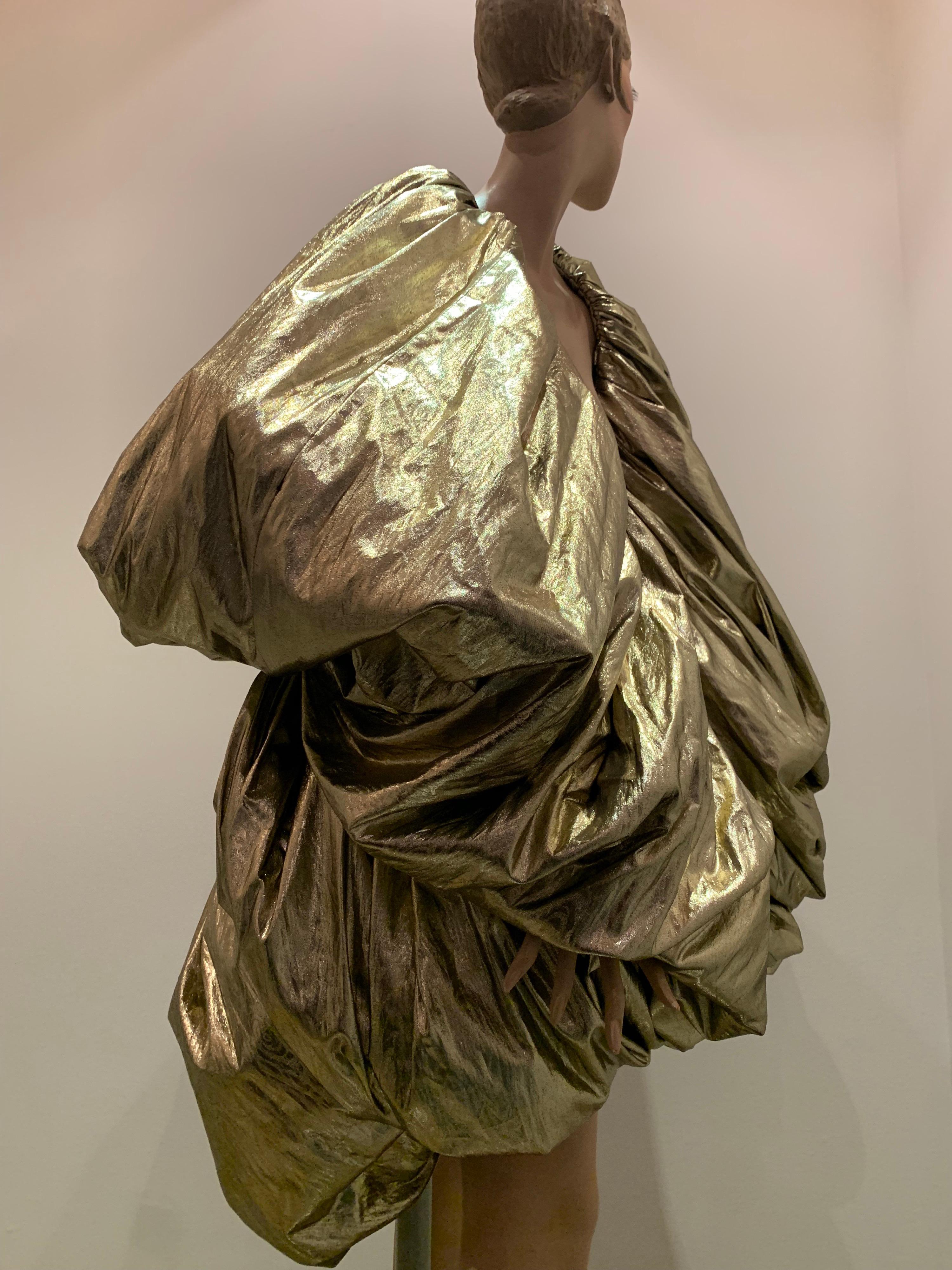 This Torso Creations gold lame over-sized balloon construction cocoon cape is dramatic and versatile. Can be worn with top looped piece up around the neck like a collar, or draped around shoulders, like a boa!  A glittering, bold statement! One size