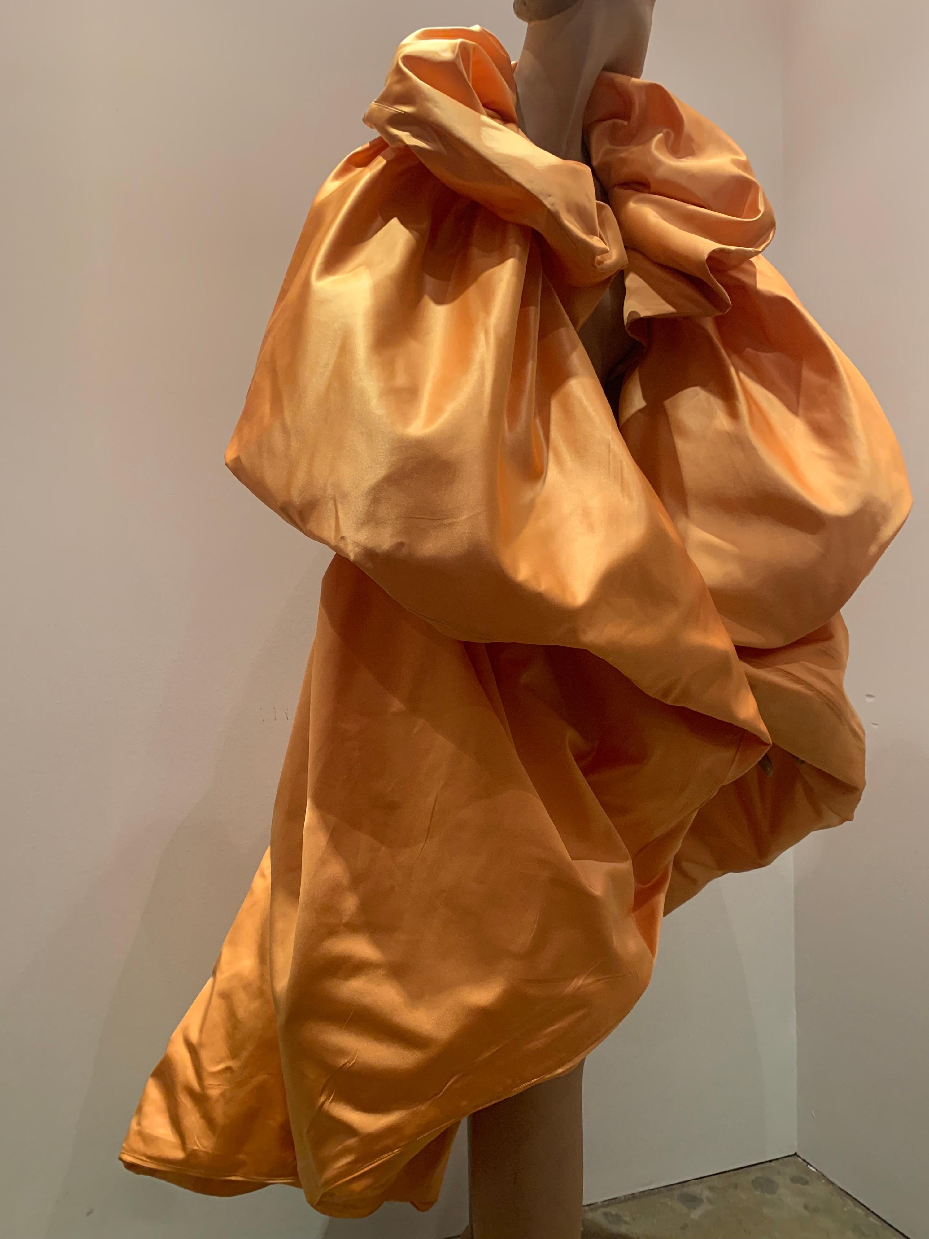 This Torso Creations marigold silk Duchess satin over-sized balloon construction cocoon cape is dramatic and versatile. Constructed with tulle interfacing for volume, it can be worn with top looped piece up around the neck like a collar, or draped