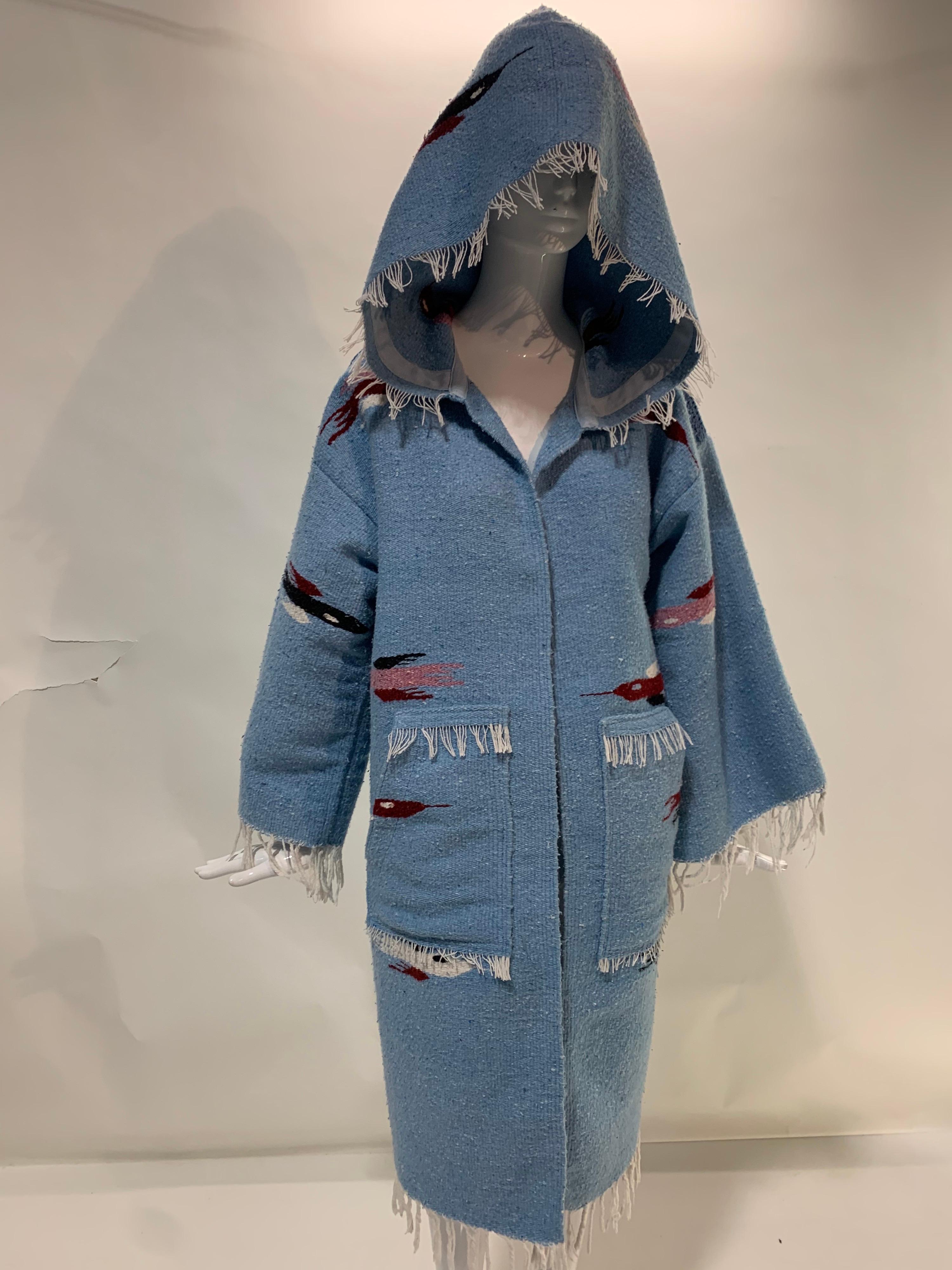 Manteau de couverture tissé à la main dans le style du Sud-Ouest, en bleu pâle, avec motif d'oiseau roadrunner stylisé, par Torso Creations. Grande capuche, poches plaquées et bords frangés. Taille Large. Fait partie de notre collection