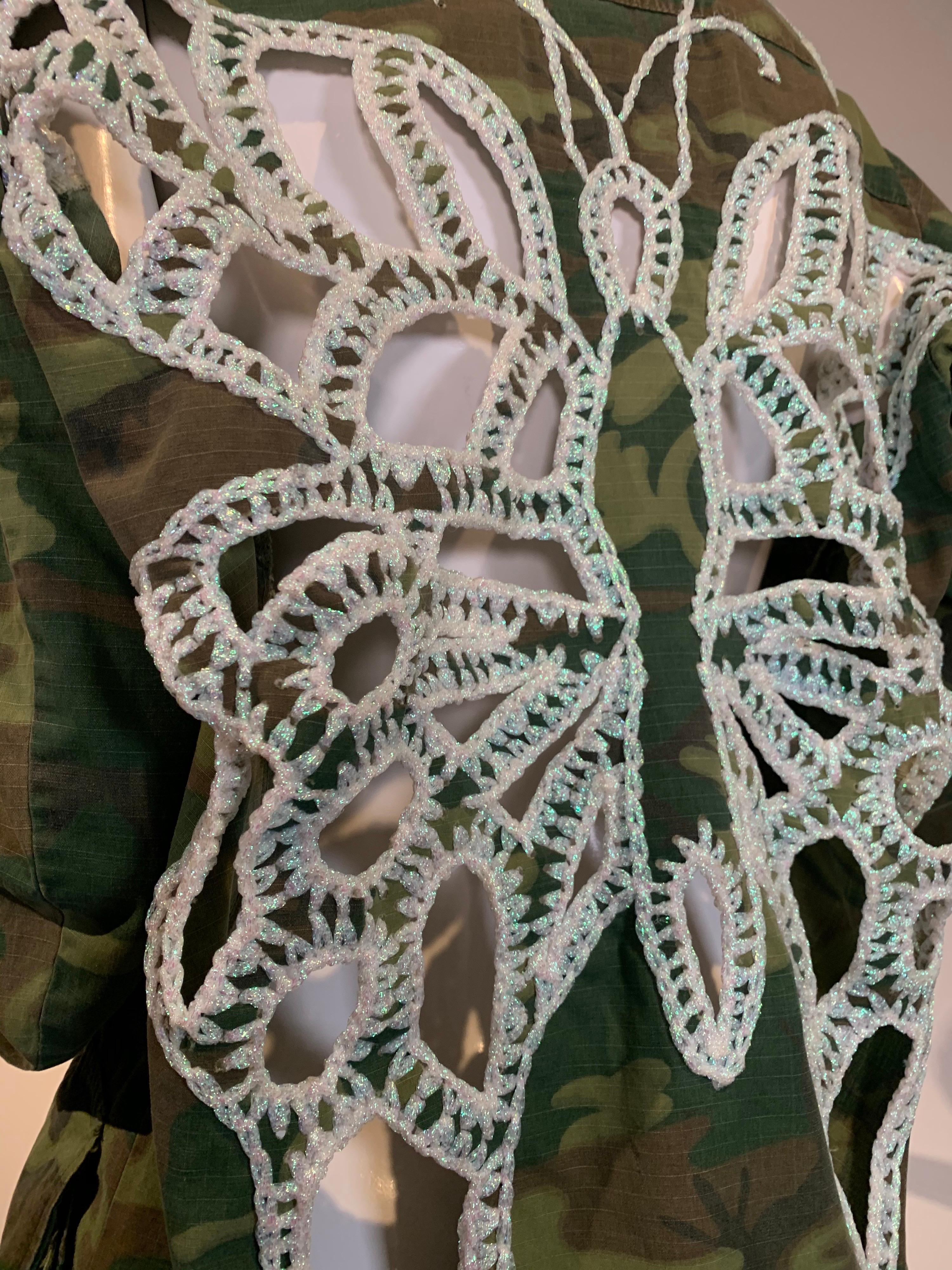 Torso Creations updates a vintage military cotton camouflage jacket with crochet and peek-a-boo butterfly design on back.  Imported, iridescent yarns edge and connect the cutout sections of this one-of-a-kind piece. Size Small-Medium 