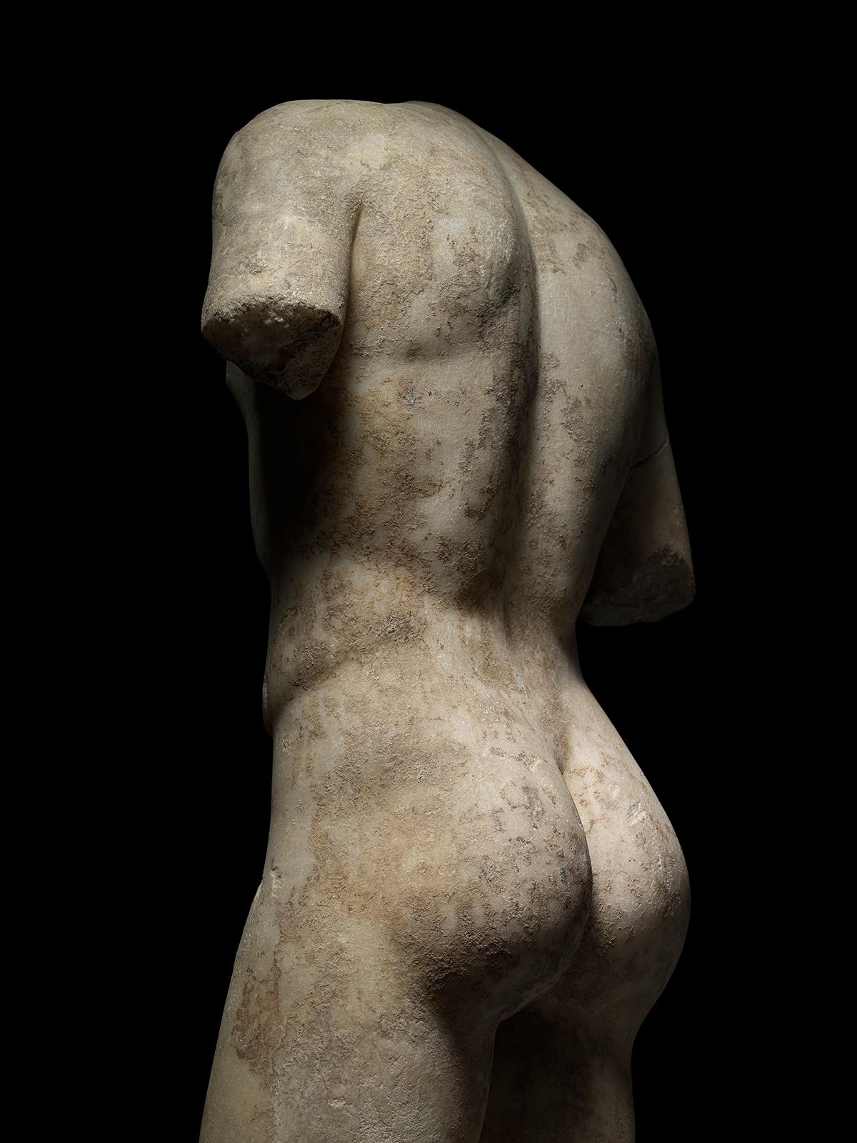 A marble statue of a youth in contrapposto position. The torso is idealised but has only softly suggested muscles, giving the impression of youth. The beginnings of the slender arms and legs further contribute to this impression, as does the languid