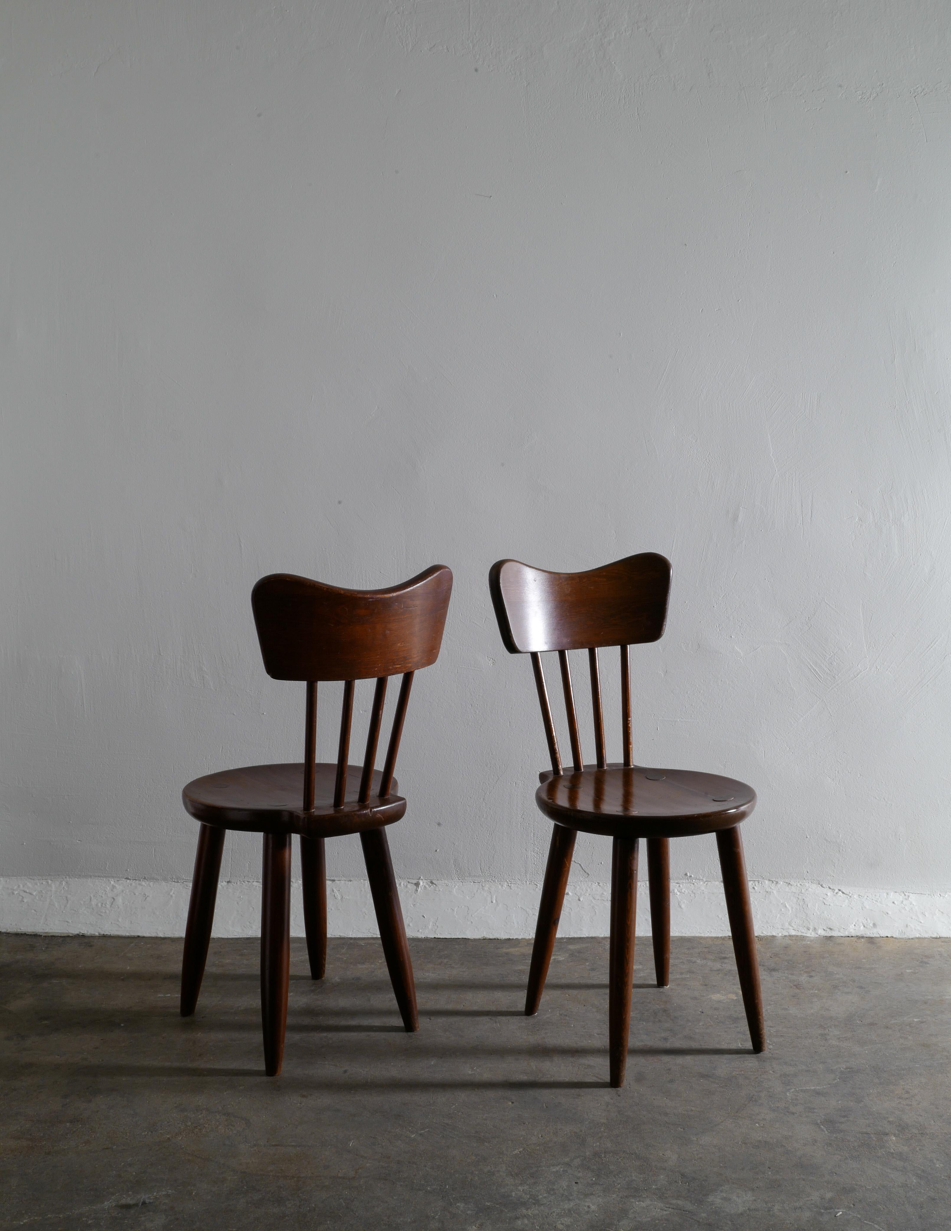 Rare set of four dining chairs by Torsten Claeson in stained pine for Steneby Hemslöjd. In good vintage condition showing patina from age and use. 