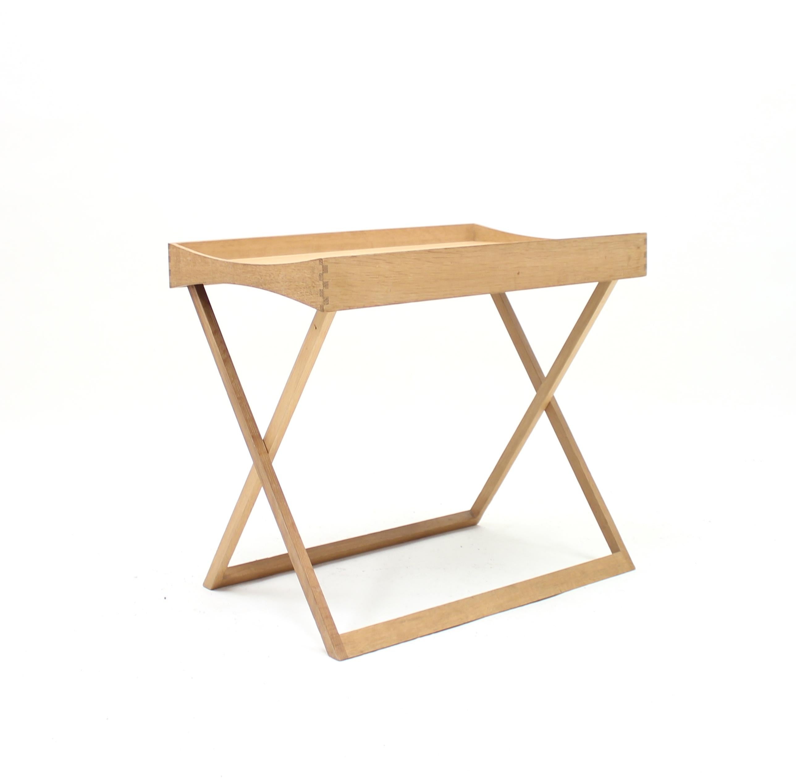 Foldable tray table designed by Torsten Johansson and manufactured by Danish company Bo-Ex in the midcentury. Black laminate top on one side and an oak top on the other that can be used with both sides up. The cross shaped legs can be folded