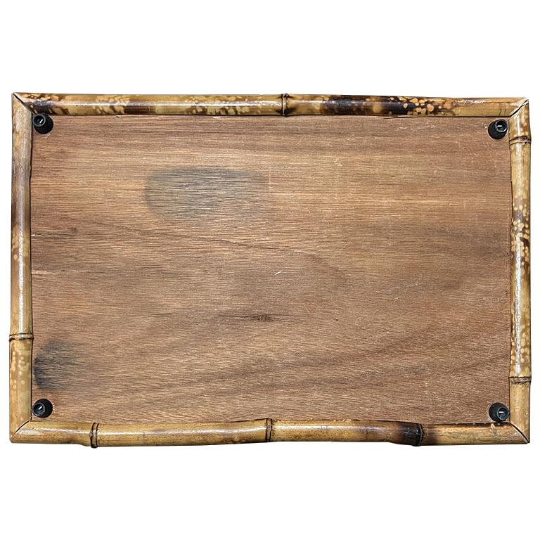 A beautiful hand-crafted tortoise bamboo (or burnt bamboo) and rattan serving tray. Created from pieces of bamboo, this tray is rectangular in form. Each side features a branch of warm brown and black bamboo stacked on top of one another to give the