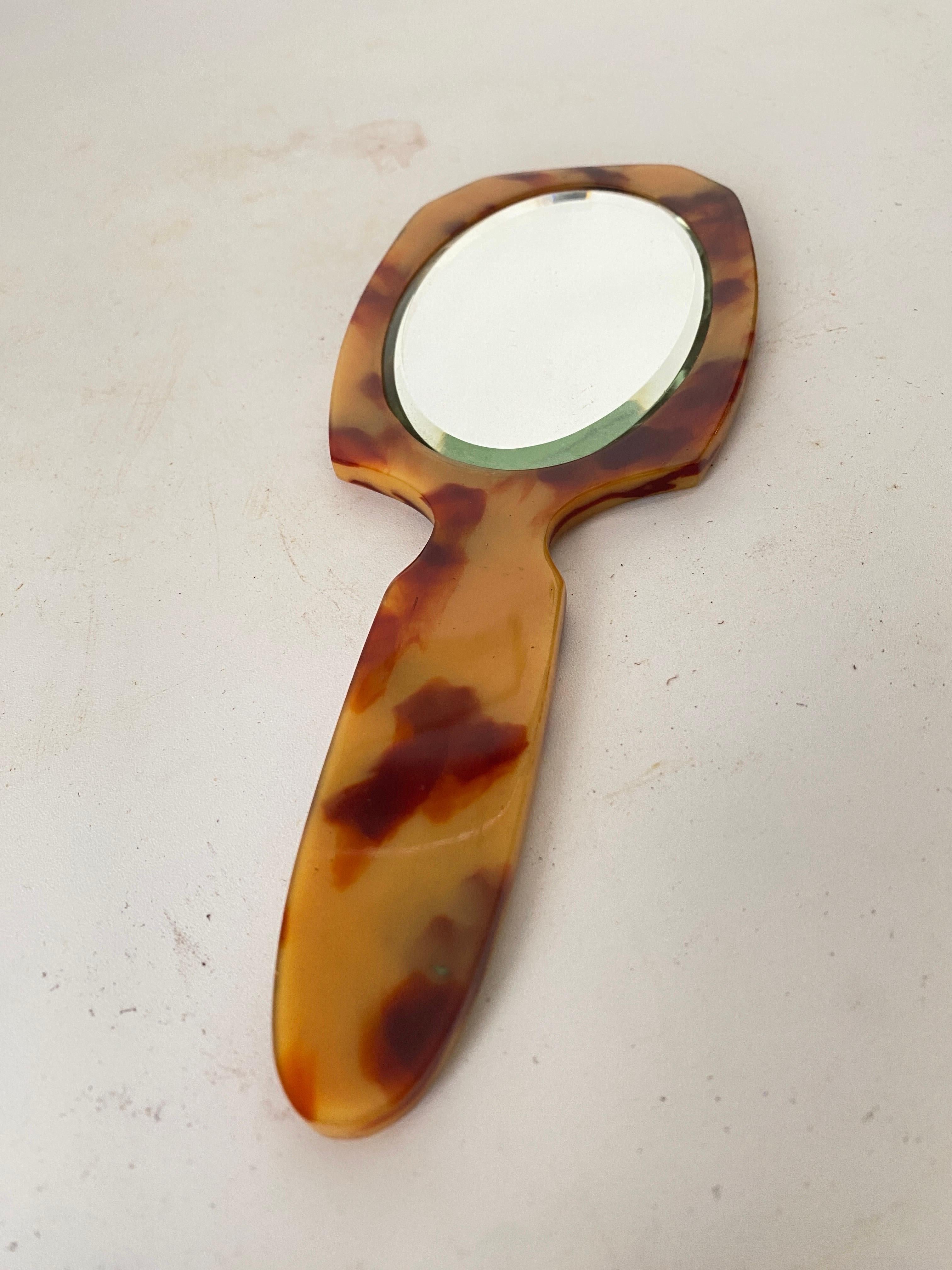This mirror an hand mirror. In faux tortoise Bakelite. It has been made in France circa 1970.
Beige and Brown color.
