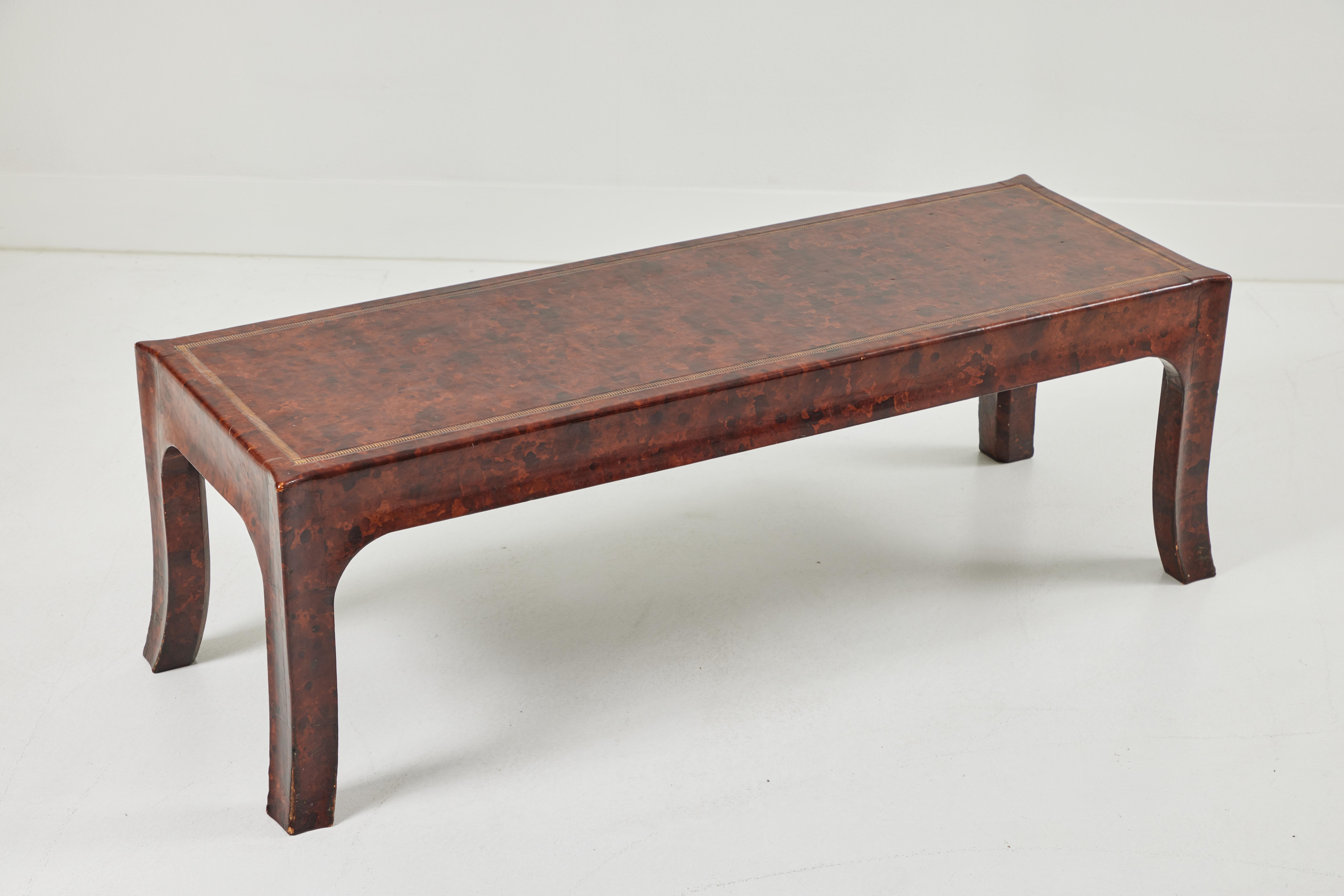 This beautifully preserved William Haines cocktail table is from the estate of Keith McCoy, a Los Angeles Legend whose showroom represented Fortuny, Robert Crowder, and P E Guerin. It is tortoise-stained leather with gold embossed detailing around