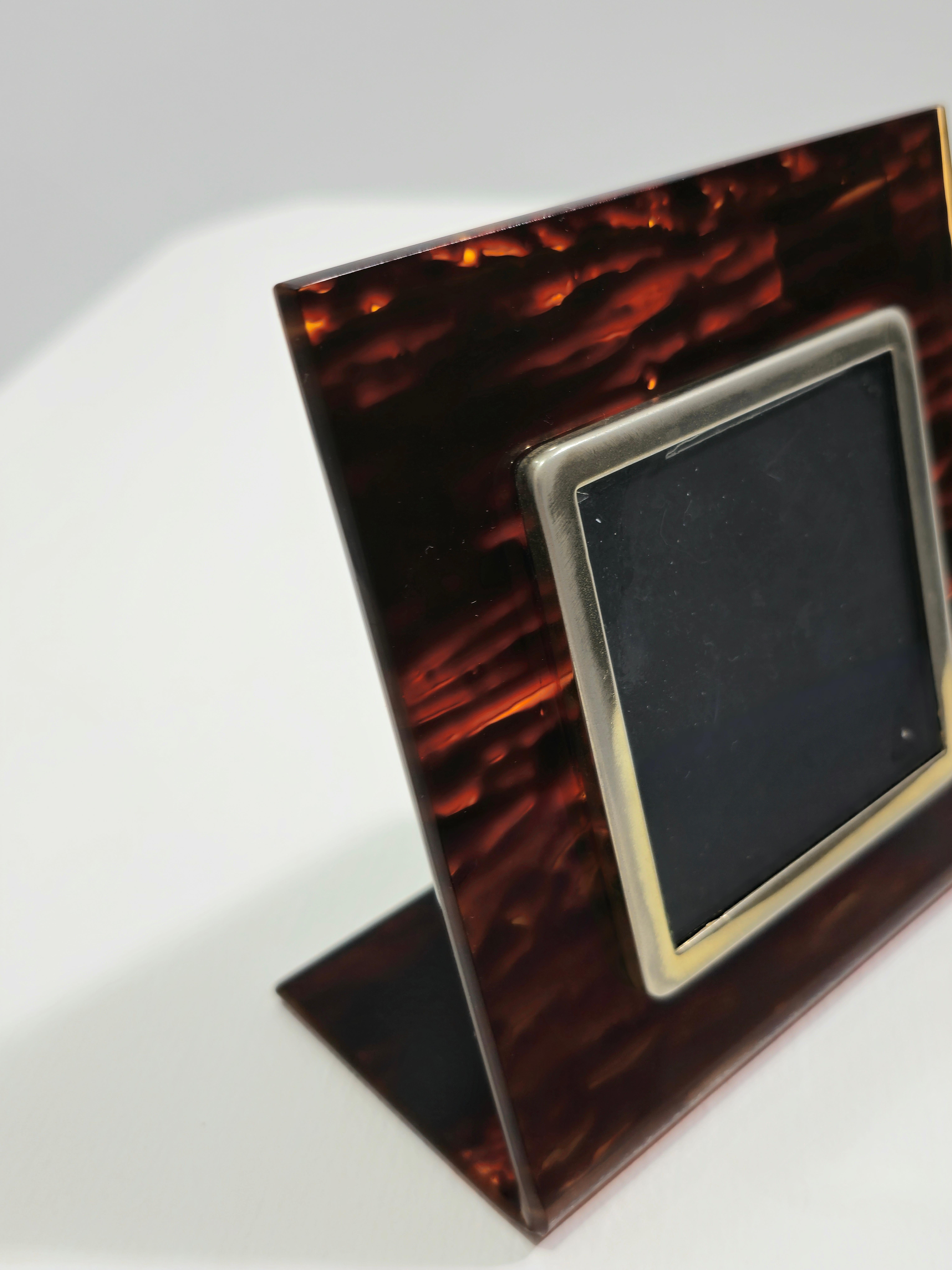 Lucite rectangular frame with brass front designed and produced in Italy. Lucite material, a type of acrylic resin, historically used for luxury items. Brown and black mottled patterns, with brass elements, which add a touch of warmth and luxury.