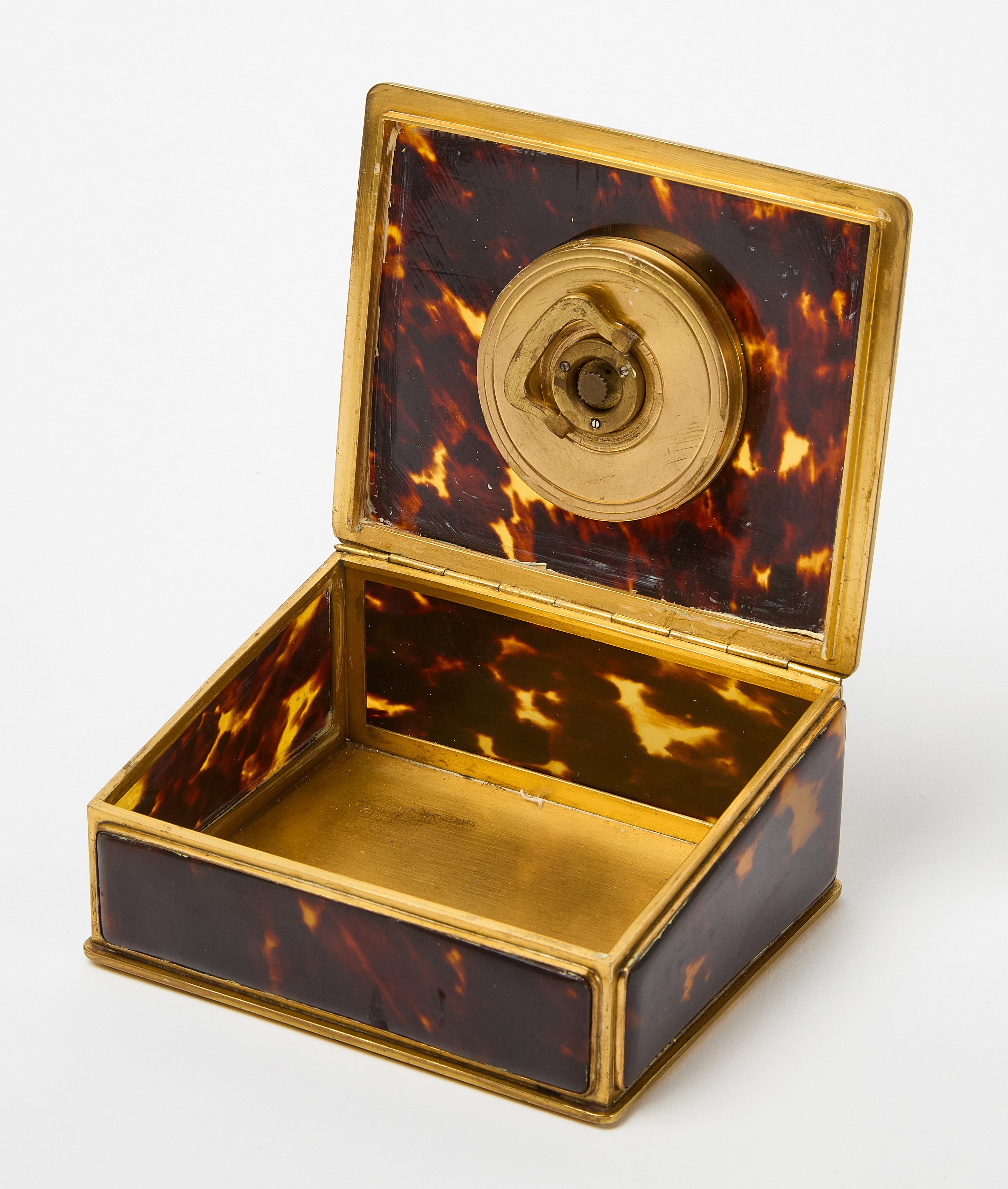 Orologio con movimento svizzero '8 Jours' incastonato in una scatola da tavolo rilegata in ottone con guscio di tartaruga. 1Circa 1940.

H. H. 2