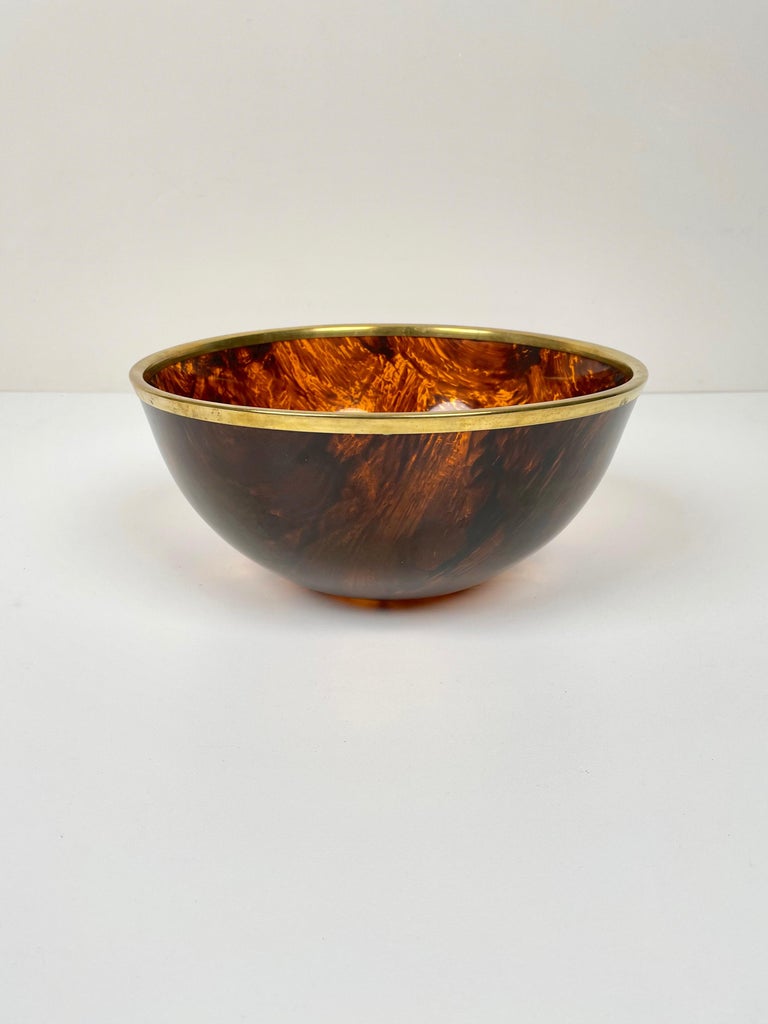 Bowl centerpiece in tortoiseshell-effect lucite with brass border in Christian Dior style made in Italy in the 1970s.