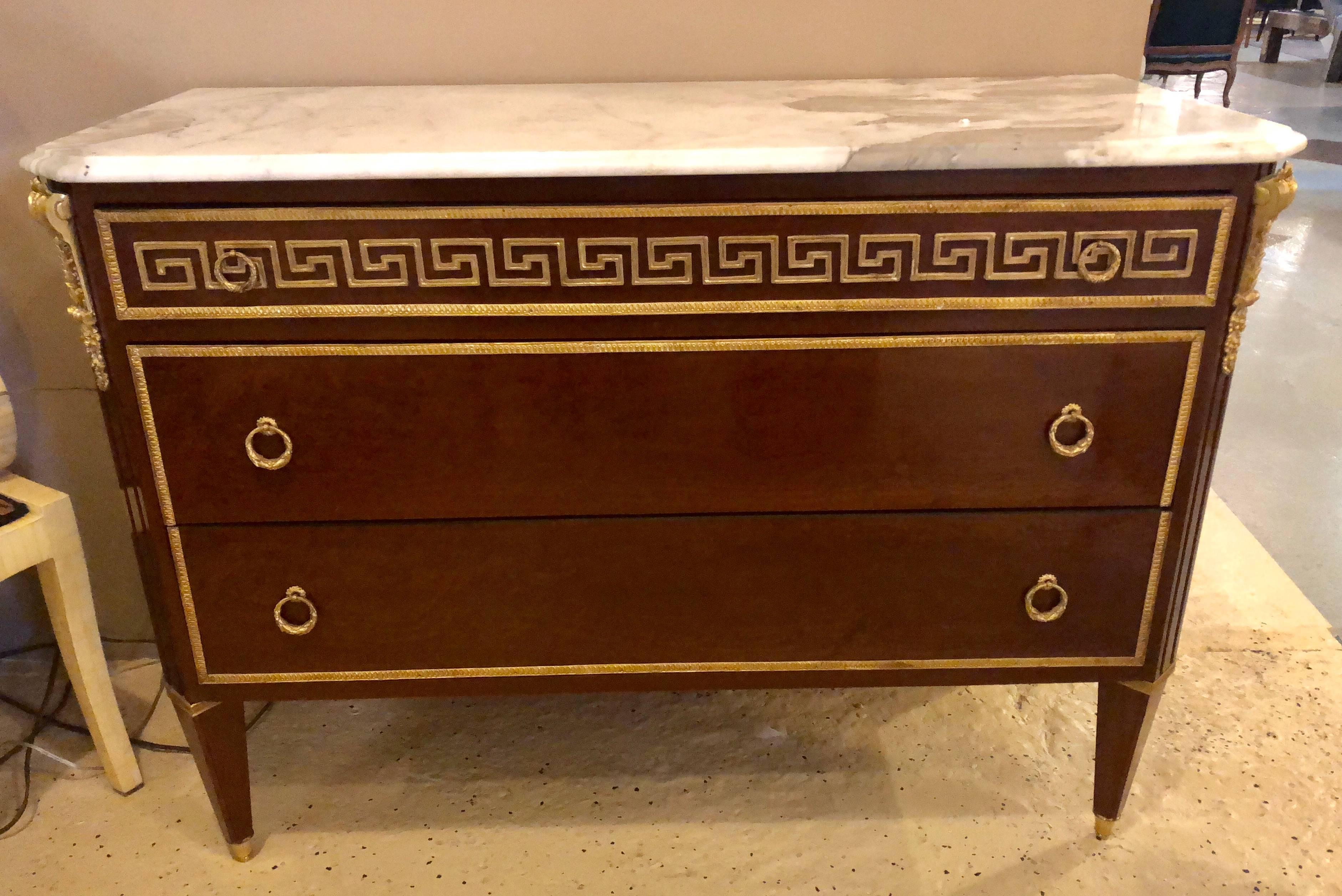 A tortoise wood bronze-mounted Greek key design commode or bedside stand in the manner of Maison Jansen. This spectacular burl walnut tortoise style three drawer commode depict the Hollywood Regency era at its finest. Having bronze framed turned and