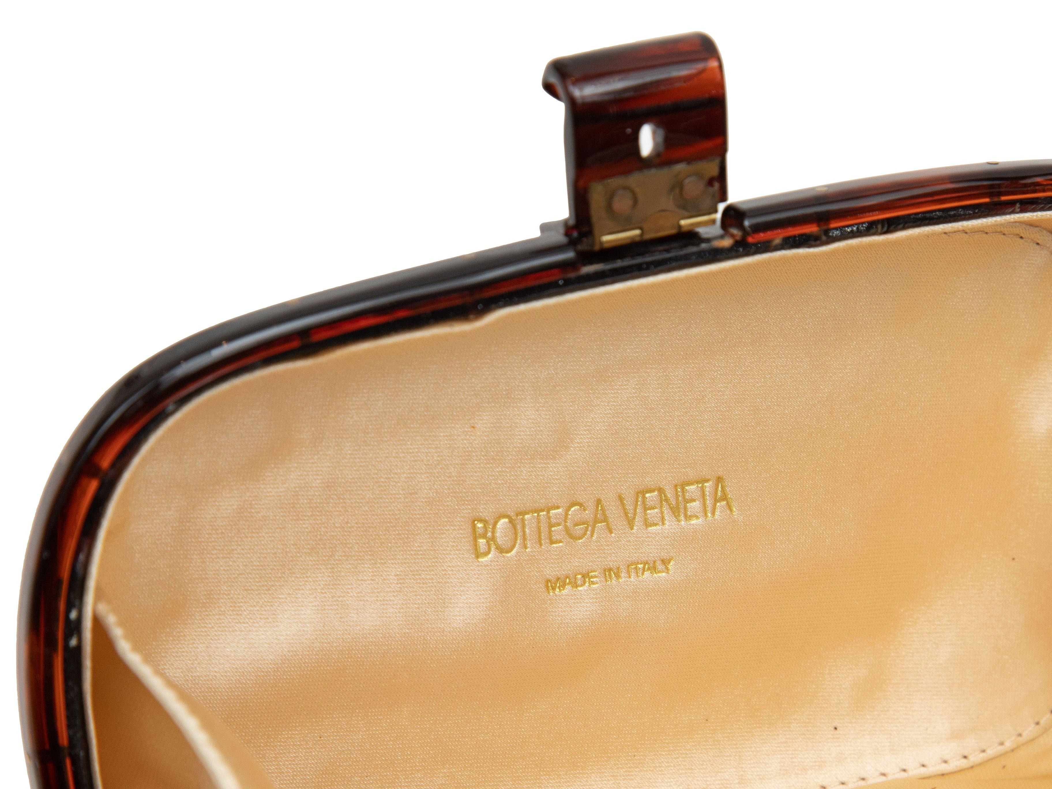 Product Details: Tortoiseshell Bottega Veneta Hard Shell Clutch. This clutch features an acrylic body, satin interior, and top clasp closure. 6