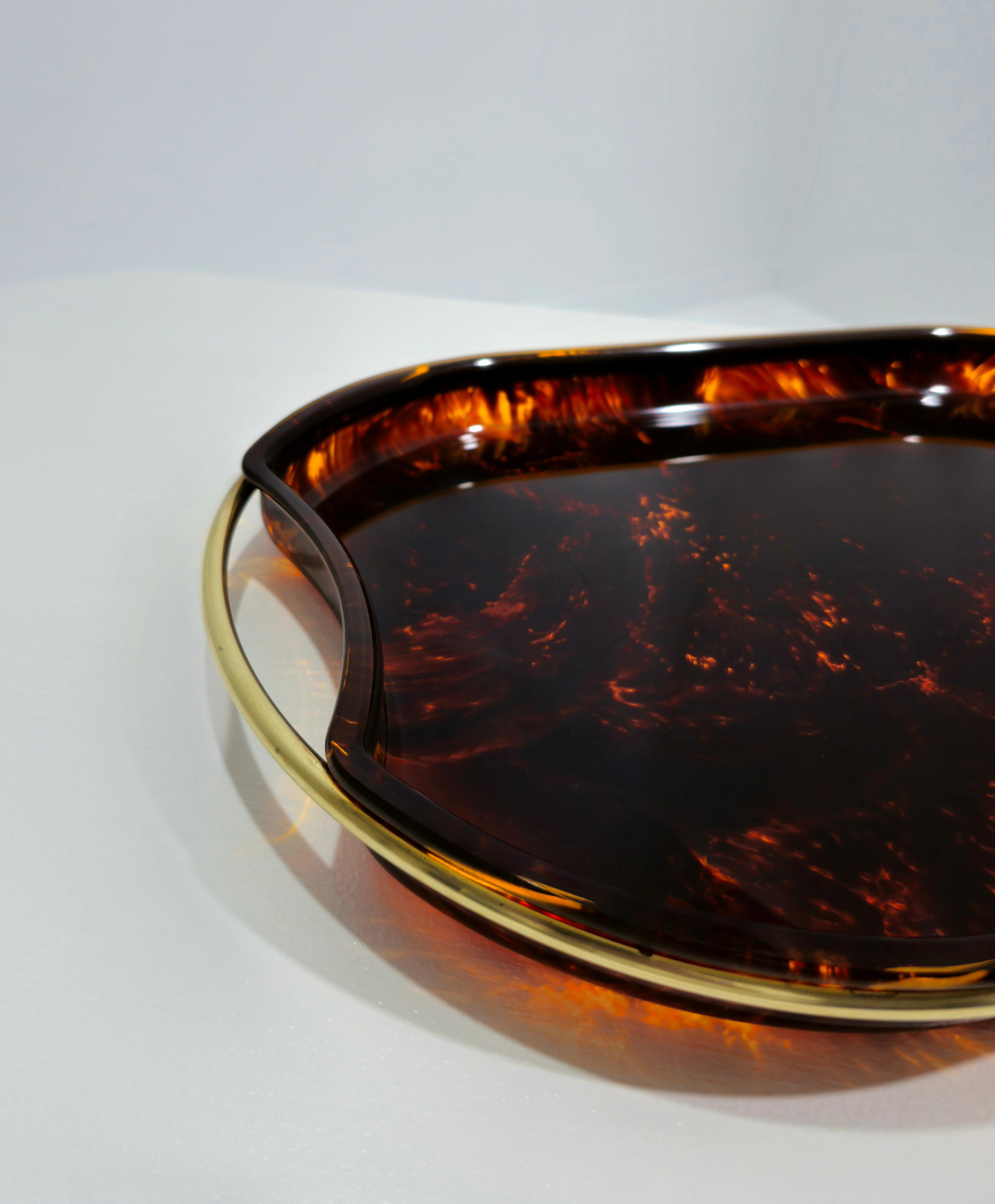 Splendido servizio da tavola della metà del secolo scorso in lucite effetto tartaruga con struttura in ottone. Questo splendido pezzo è stato prodotto in Italia negli anni Settanta.
Un iconico vassoio o piatto da portata in lucite tartarugata con