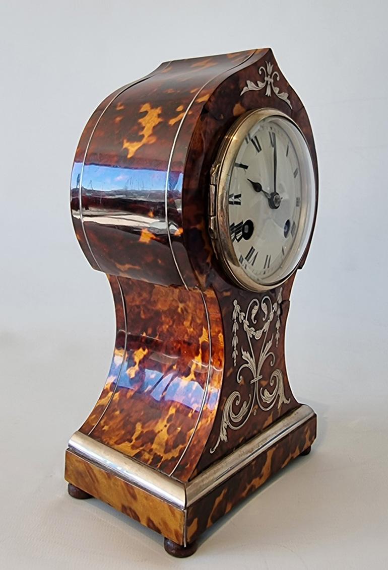 Antique English tortoiseshell mantel clock with silver inlay, mouldings and stringing.T he balloon waisted case with arch top.
Most unusually with gold leaf laid under tortoiseshell for a very rich golden colour to the tortoiseshell. 
Convex white