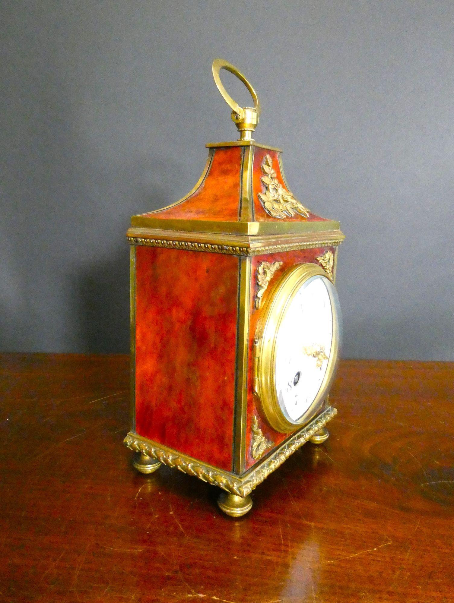 Tortoiseshell Pendule D’Officier Mantel Clock

Tortoiseshell mantel clock in a Pendule D’Officier style case with ormolu mounts, brass feet and surmounted by a hinged brass carrying handle.
Brass bezel with convex glass opening to the enamel dial