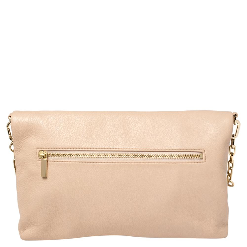 You do not want to miss out on this adorable Tory Burch creation. This gorgeous bag is crafted from leather in a beige hue. It comes detailed with the brand logo on the foldover front flap. The interior is lined with fabric and houses one zipper