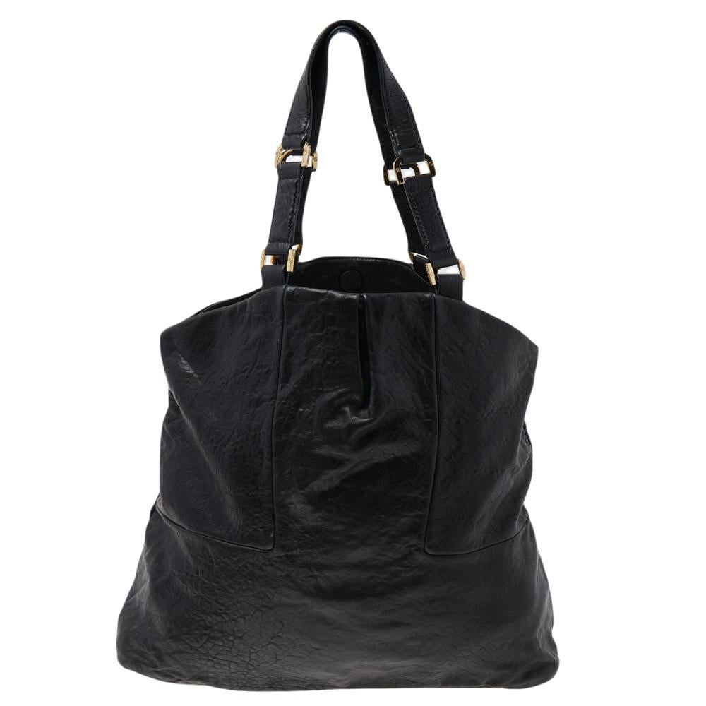 Featuring dual handles and a classic black shade, this Tory Burch tote exudes just the right amount of sophistication. The leather bag comes equipped with a capacious canvas compartment to house all your daily essentials. Flaunting logo-detailed