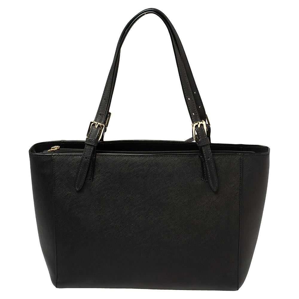 Featuring dual buckle handles and a classic black shade, this Tory Burch tote exudes just the right amount of sophistication. The leather bag comes equipped with a capacious fabric interior to house all your daily essentials. Flaunting the brand