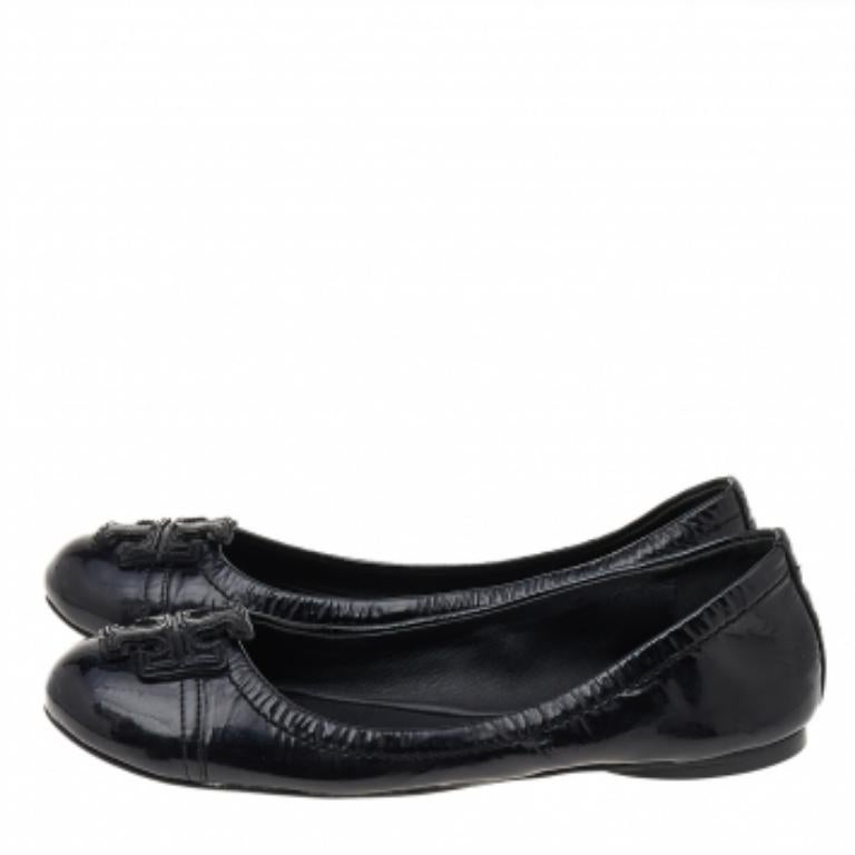 Tory Burchs zeitlose Ästhetik und hervorragende Handwerkskunst in der Schuhmacherei zeigt sich in diesen vielseitigen Flats. Die runde Zehensilhouette aus schwarzem Lackleder ist mit Logos auf dem Obermaterial verziert.