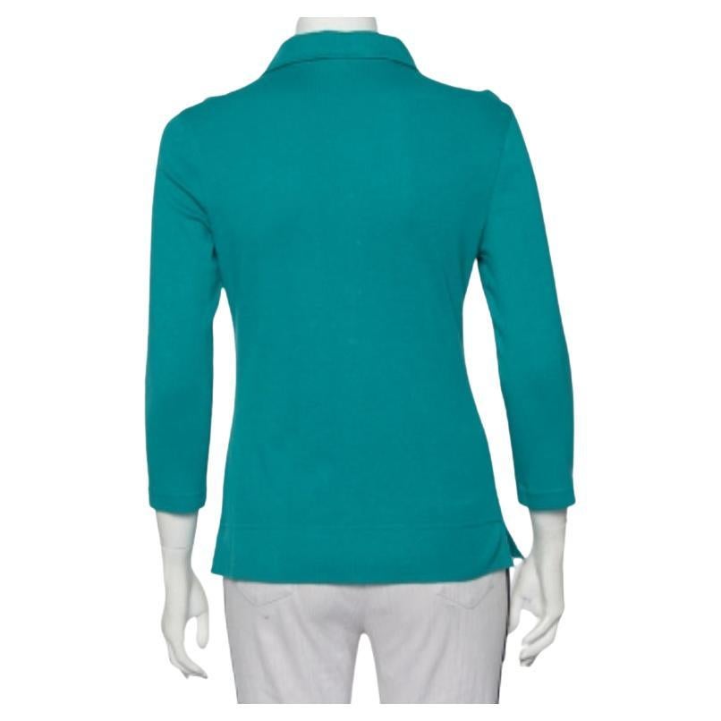 Esta camiseta polo de Tory Burch, una mezcla perfecta de comodidad, lujo y estilo, es una prenda imprescindible. Confeccionada en algodón de color azul, esta creación se realza con una tapeta abotonada y un cuello clásico. Se puede combinar con
