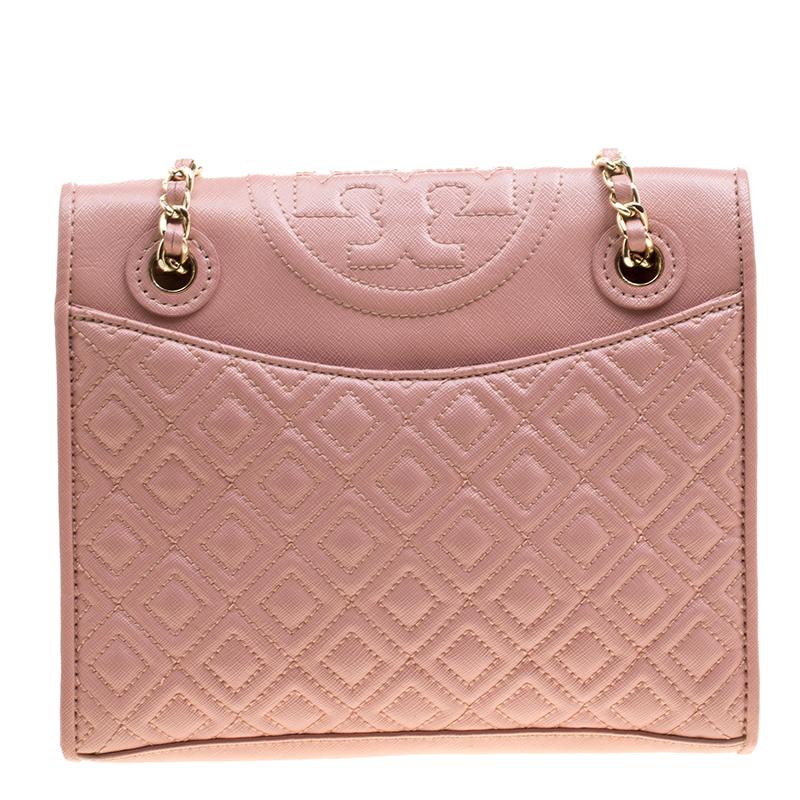 This Fleming shoulder bag from Tory Burch has been meticulously crafted from leather in a dreamy blush pink hue and designed with quilts in diamond patterns and the logo on the top. The flap opens to a fabric-lined interior and the bag is held by an