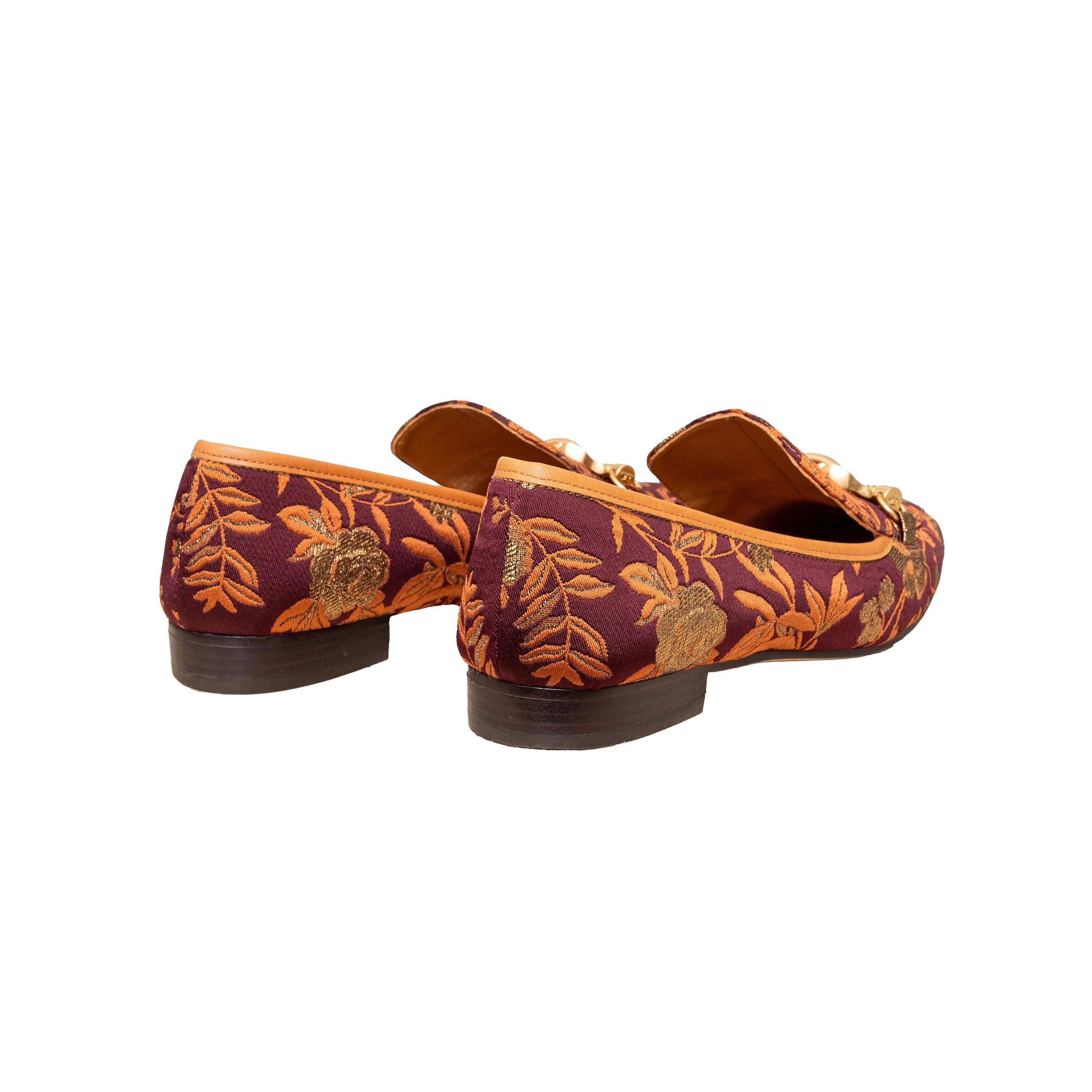 Slip into vintage inspired style with Tory Burch Brocade Loafers. Made with leather and brocade lurex fabric, these cool mocassins feature a delicate floral jacquard motif in burgundy, gold, and orange. The gold colored metal seahorse detail on the