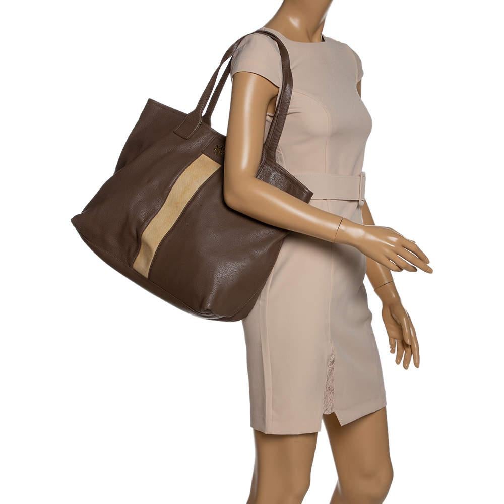 Diese Shopper-Tasche von Tory Burch ist aus braunem und beigem Leder gefertigt und besticht durch ihren Stil.  Sie hat zwei Griffe an der Oberseite und der mit Nylon gefütterte Innenraum bietet viel Platz, so dass Sie Ihre alltäglichen Dinge leicht