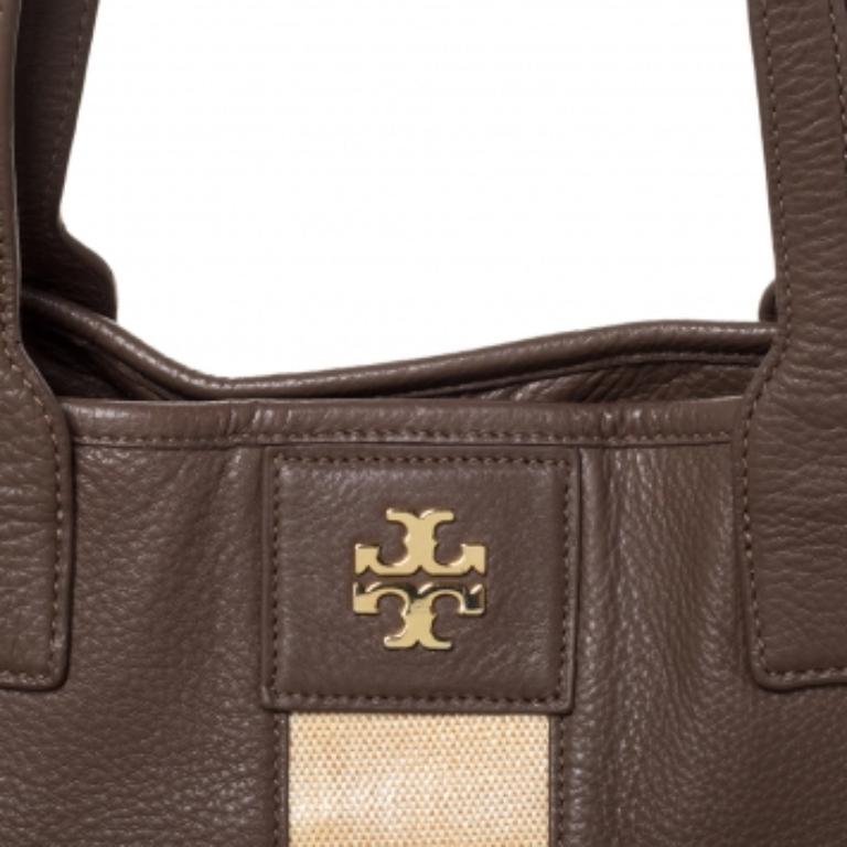 Impressive and high on style, this shopper tote from Tory Burch comes made from brown and beige leather.  It has dual top handles and the nylon-lined interior offers a lot of space just so that you can easily carry your daily essentials.