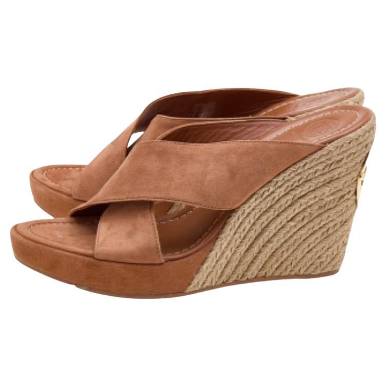 Take your style a few notches higher with these sandals from Tory Burch. Crafted from brown suede and styled with open toes, they have criss-cross straps and 12 cm wedge heels. They'll look great with your casual outfits.