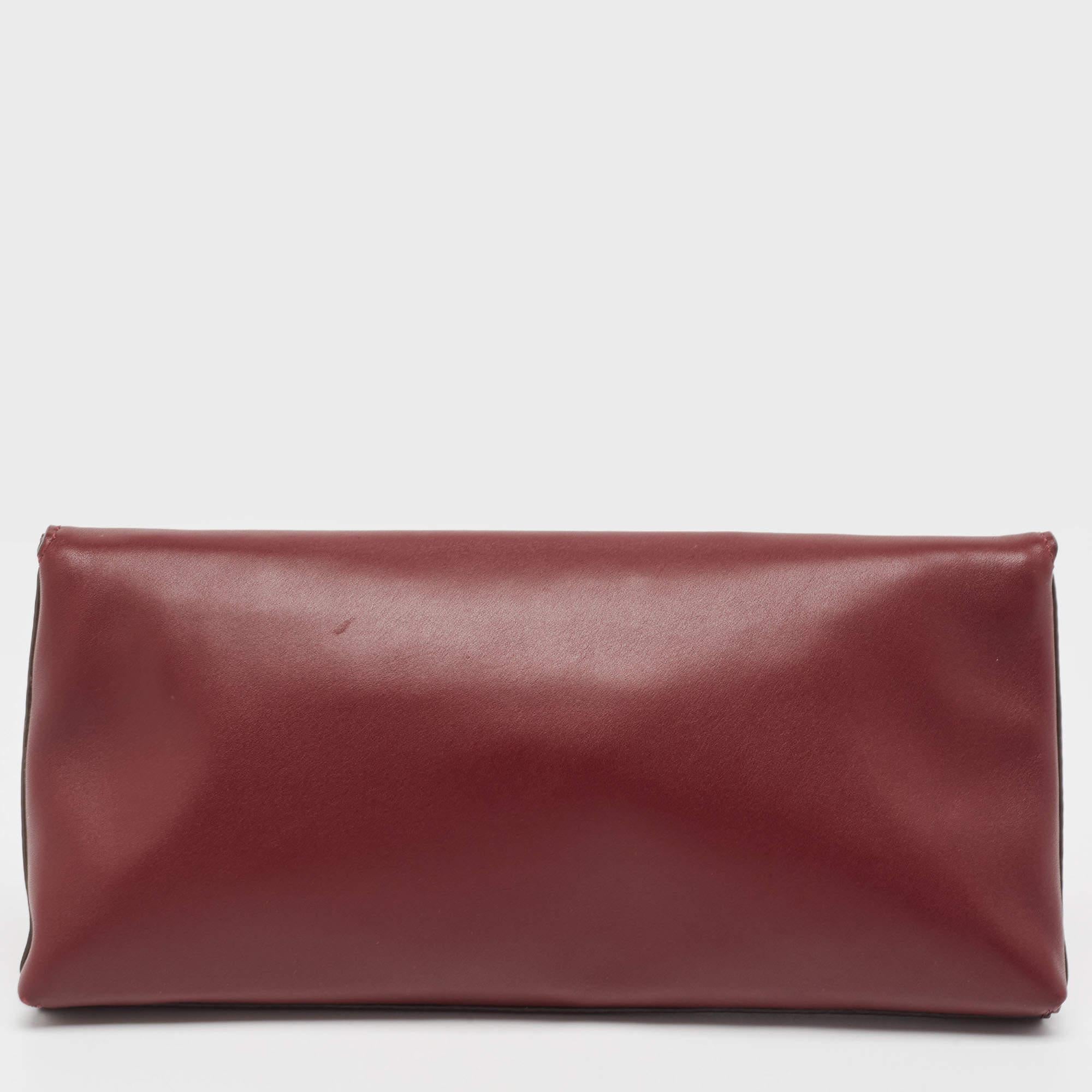 What a cool way to carry your belongings! This Miller clutch from the House of Tory Burch is designed lavishly from burgundy leather with a logo accent on the front. It is embellished with gold-toned hardware and features a canvas-lined