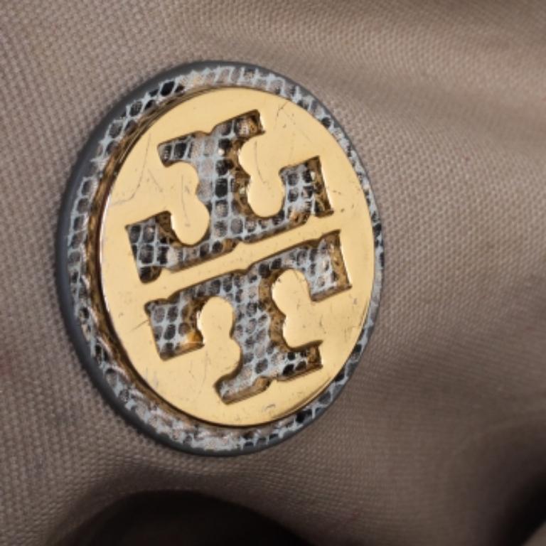 Simply gorgeous and stylish, this Simon bag from Tory Burch deserves to be yours! It has been crafted from python-embossed leather and adorned with a gold-tone turn lock on the front flap. It opens to a canvas-lined interior that can easily