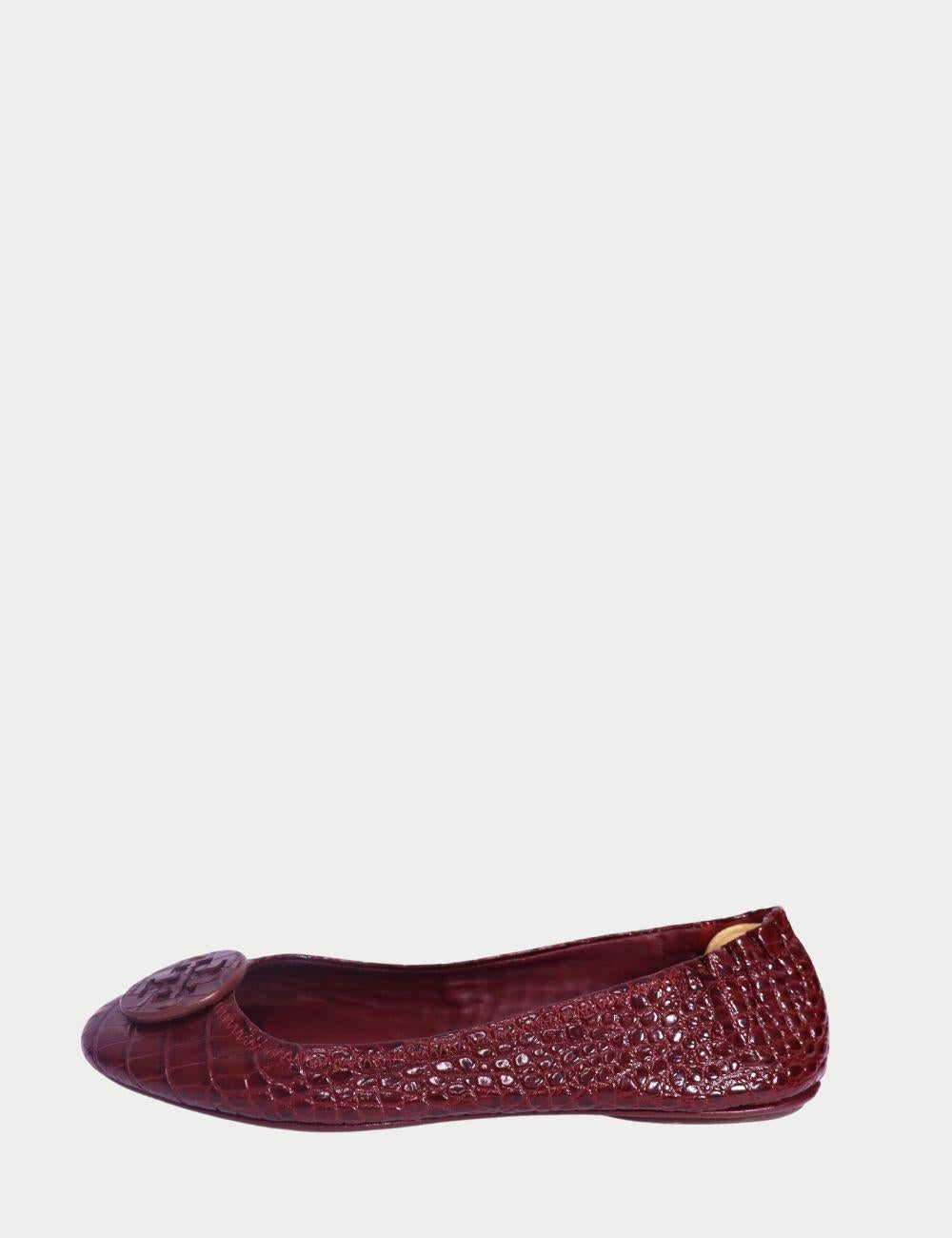 Tory Burch Burgundy Croc-Embossed Minnie Ballet Flats

Elevate your flats game with these chic Tory Burch Minnie Ballet Flats in a rich burgundy hue. Crafted from croc-embossed leather, these classic round-toe shoes feature a tonal Tory Burch