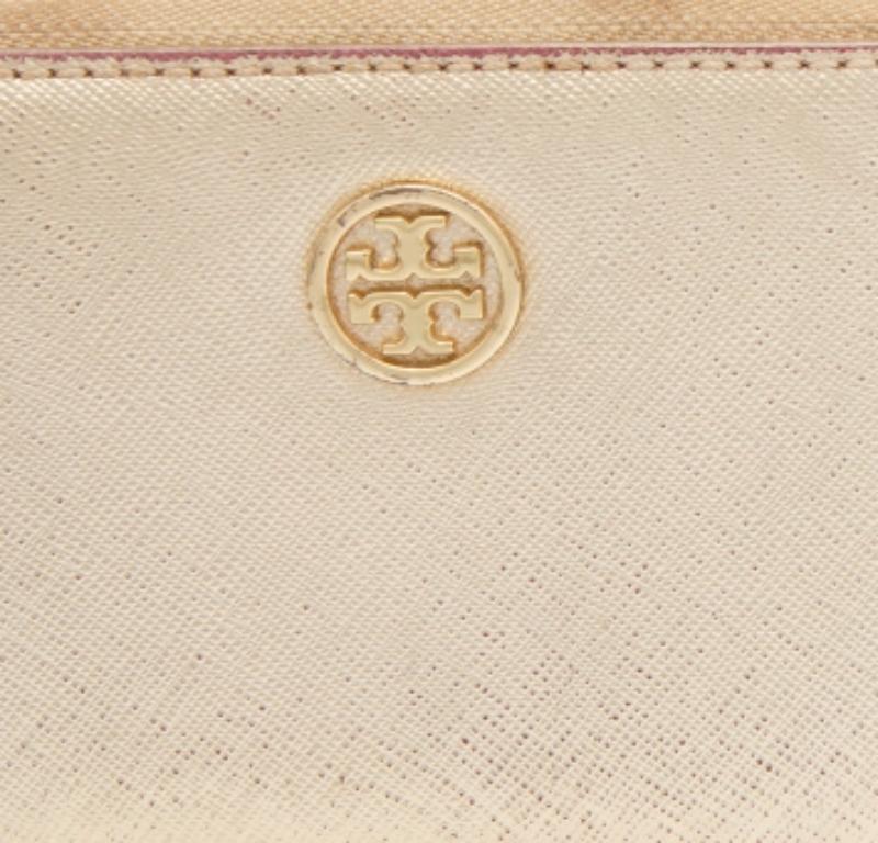 Dieses Portemonnaie von Tory Burch ist aus strukturiertem Leder in einem Goldton auf der Außenseite gefertigt und verfügt über ein Armband, ein Logo auf der Vorderseite und einen Reißverschluss. Der mit Stoff und Leder gefütterte