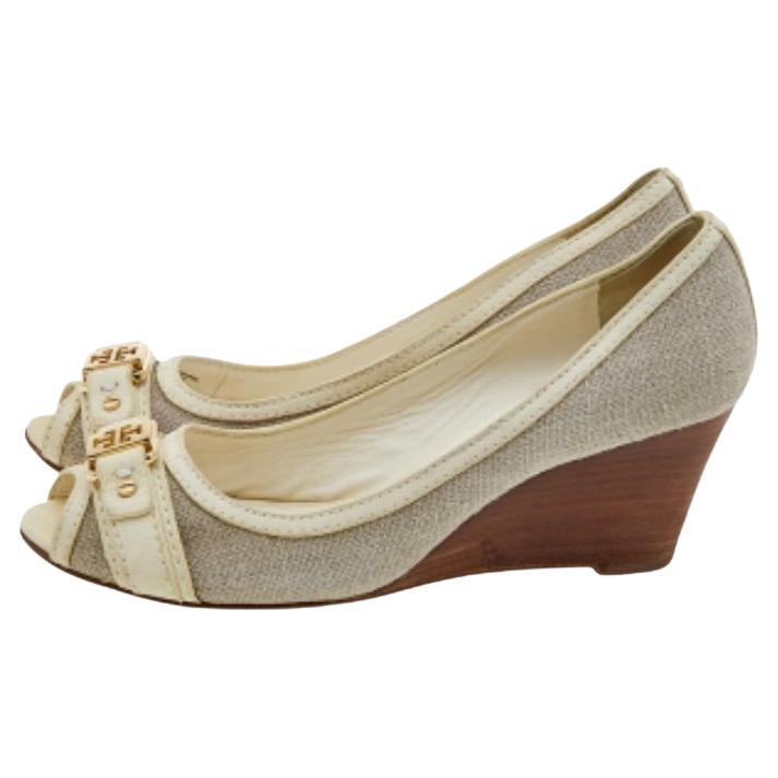 These pumps from Tory Burch are simple but a must-have. Crafted using canvas and leather, and balanced on wedges, the peep-toe pumps are complete with the brand logo on the uppers. They are high in both style and comfort.
