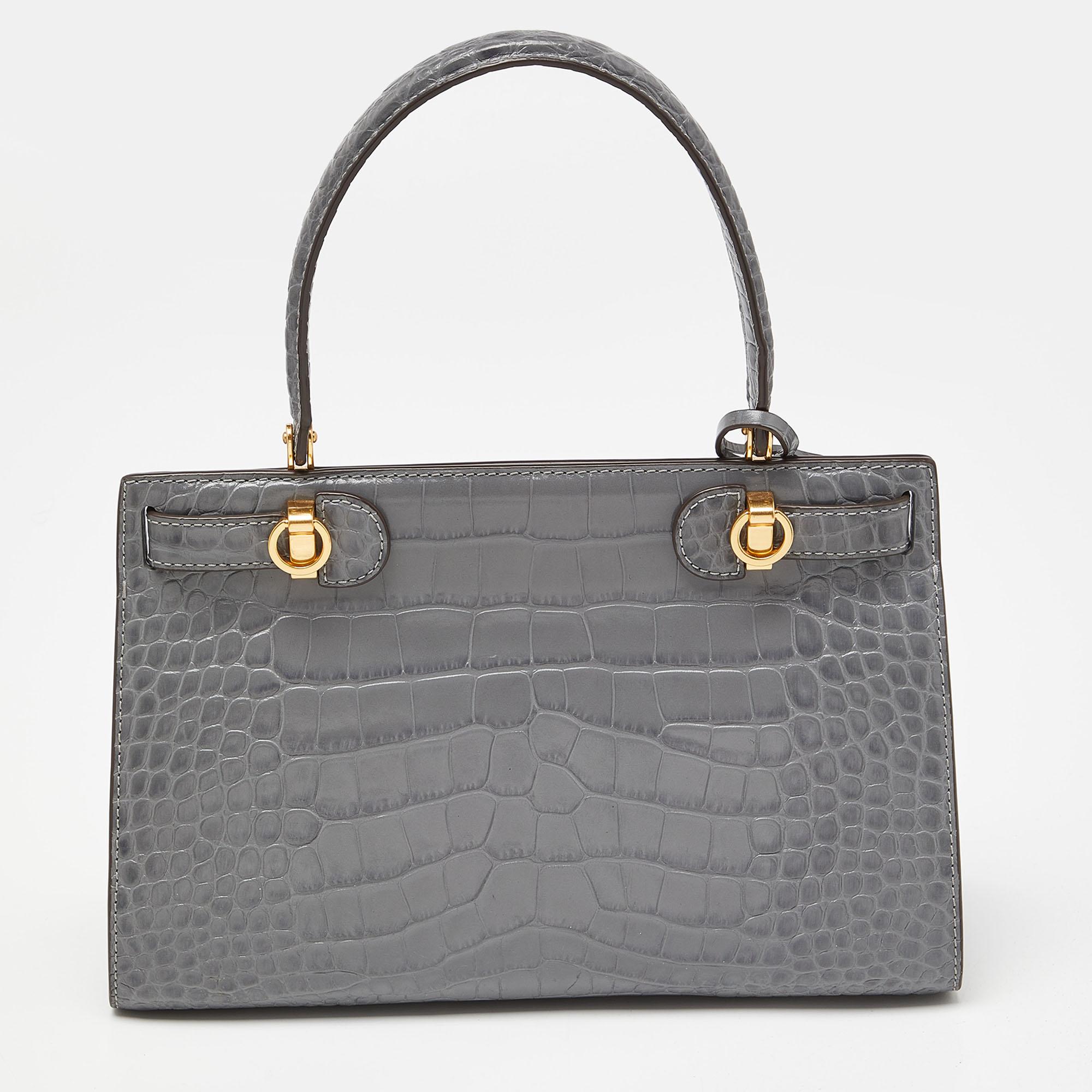 Designed with croc-embossed leather, this bag is an excellent adornment to carry every day. The leather interior is well-sized, and the top handle is easy to hold. Designed to last, this handbag from Tory Burch will elevate your outfit.

Includes:
