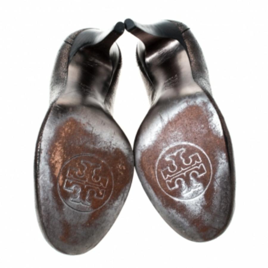 Ces escarpins gris métallisé de Tory Burch sont simples mais indispensables. Confectionnés en cuir et montés sur des talons de 9.5 cm, ces escarpins à bout rond sont ornés du logo de la marque sur l'empeigne. Ils sont à la fois élégants et