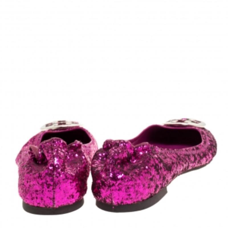 Dale un toque lujoso a tus conjuntos informales con estas elegantes bailarinas rosa metalizado de Tory Burch. Confeccionadas con tejido grueso de purpurina y diseñadas con detalles de logotipos en la parte superior, ofrecen un estilo scrunch y son