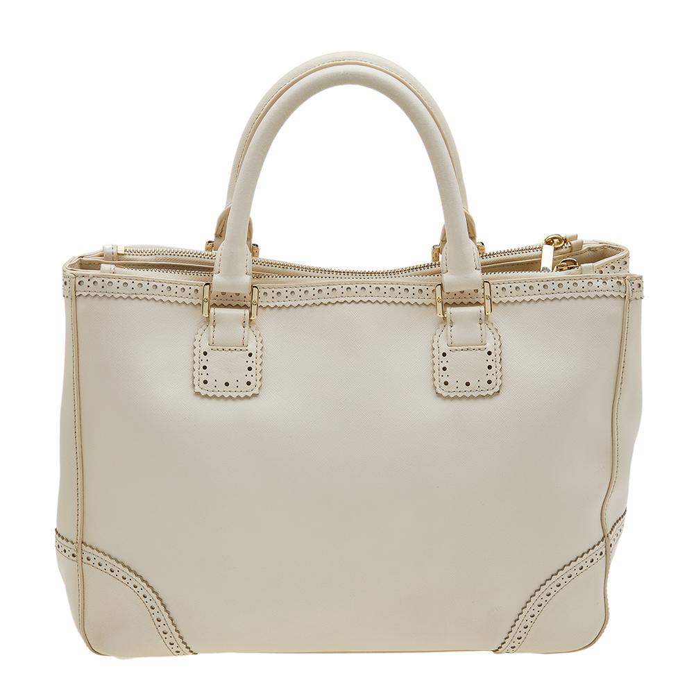 This Tory Burch leather tote has been crafted with attention to detail. Lined with fabric, the roomy interior is secured with double zipper closure at the top. While the dual handles and a shoulder strap make it comfortable to carry, the brand logo