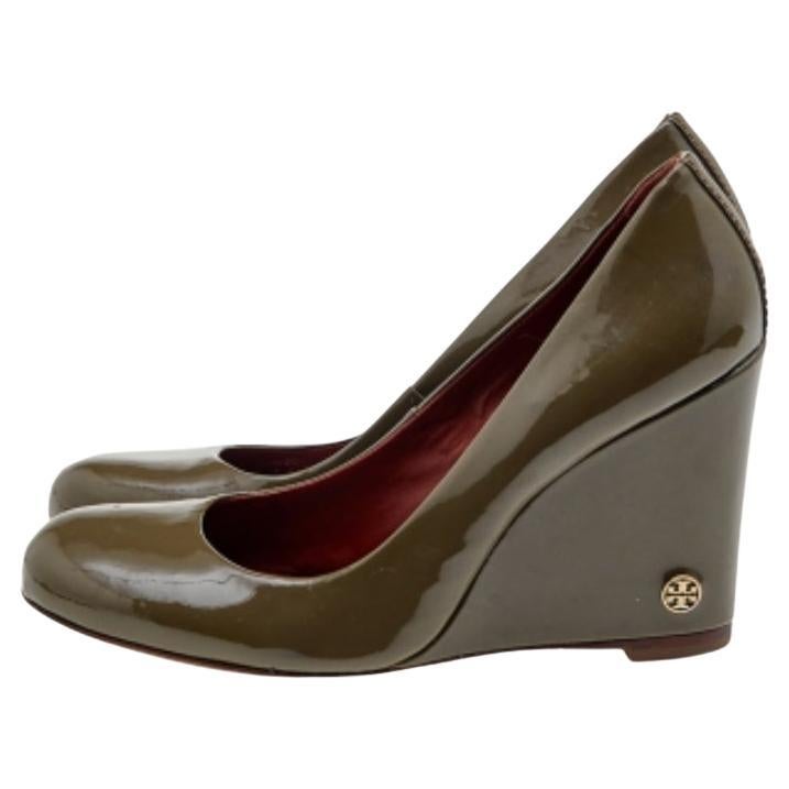 These olive green pumps from Tory Burch are simple but a must-have. Crafted using patent leather, and balanced on 10 cm wedges, the round-toe pumps are complete with the brand logo on the heels. They are high in both style and comfort.