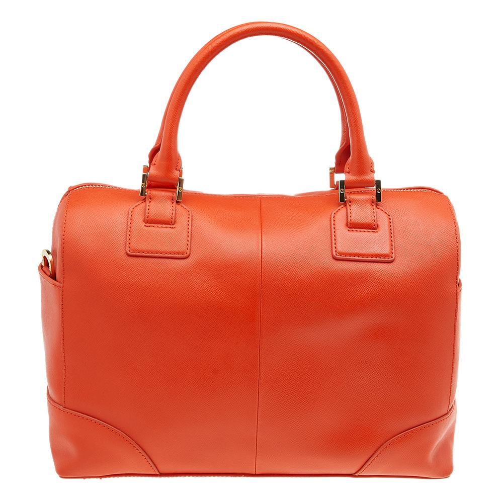 An ideal everyday accessory, this Tory Burch satchel comes in a pleasing orange shade. Created from leather on the exterior, it exhibits a brand signature on the front, dual handles, and a shoulder strap. The canvas-lined interior is equipped with a