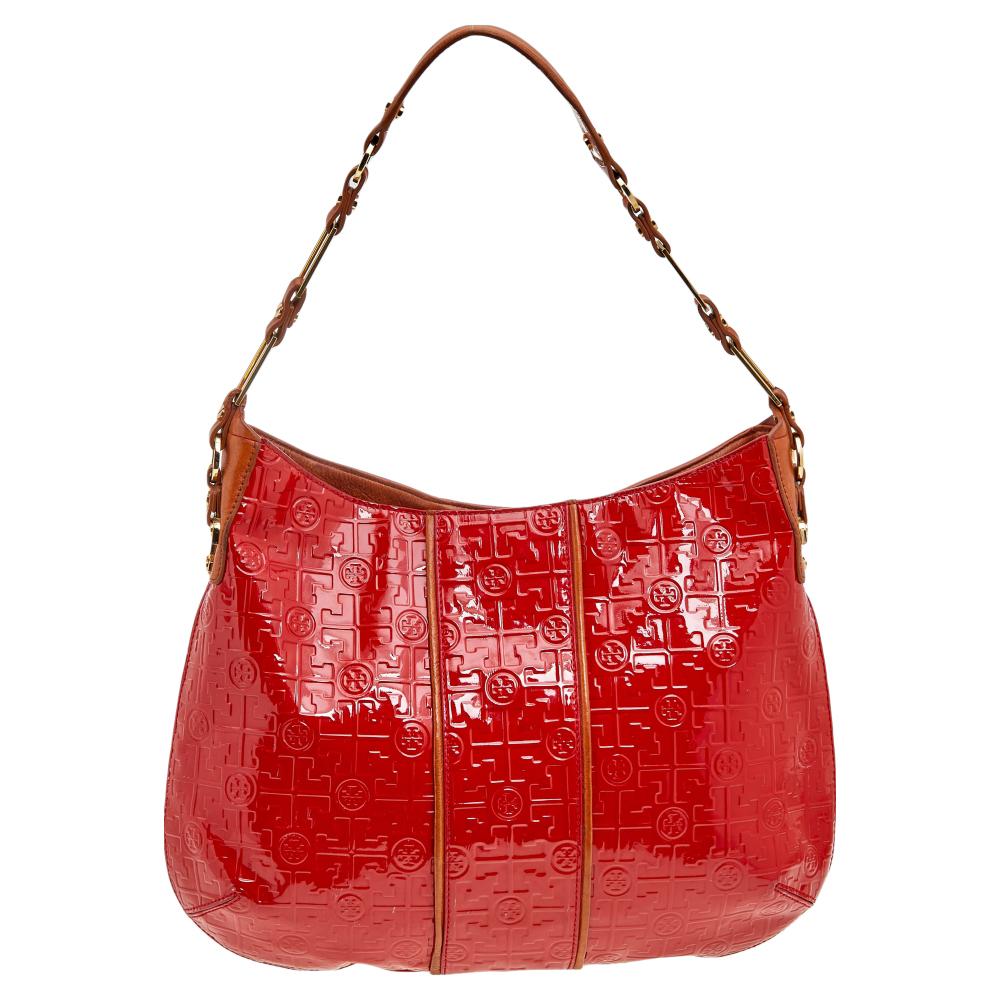 Add a pop of color and style to your ensemble as you carry this beautiful hobo from the House of Tory Burch. It is made from patent leather on the exterior and showcases a top handle, fabric-lined interior, and gold-toned hardware. This hobo is
